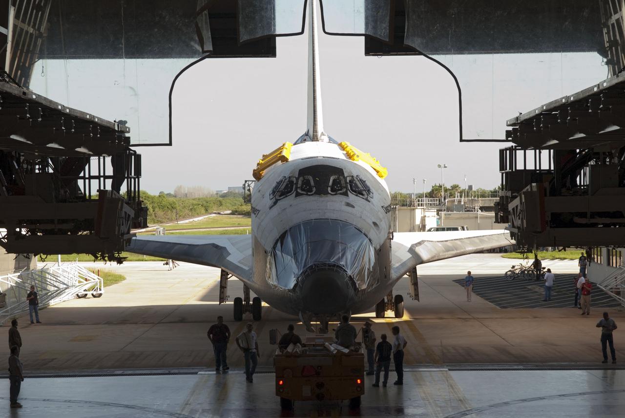 CAPE CANAVERAL, Fla. -- At NASA's Kennedy Space Center in Florida, space shuttle Discovery backs out of its processing bay, Orbiter Processing Facility-2, or OPF-2, to begin the move to the Vehicle Assembly Building, or VAB. Discovery will be stored inside the VAB for approximately one month while shuttle Atlantis undergoes processing in OPF-2 following its final mission, STS-135. Discovery flew its 39th and final mission, STS-133, in February and March 2011, and currently is being prepared for public display at the Smithsonian's National Air and Space Museum Steven F. Udvar-Hazy Center in Virginia. For more information about Discovery's Transition and Retirement, visit www.nasa.gov/mission_pages/shuttle/launch/discovery_rss_collection_archive_1.html. Photo credit: NASA/Jim Grossmann