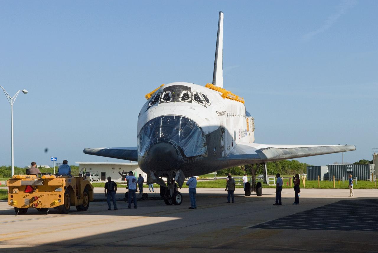 CAPE CANAVERAL, Fla. -- At NASA's Kennedy Space Center in Florida, workers "spot" for space shuttle Discovery as it rolls from Orbiter Processing Facility-2, or OPF-2, to the Vehicle Assembly Building, or VAB. Discovery will be stored inside the VAB for approximately one month while shuttle Atlantis undergoes processing in OPF-2 following its final mission, STS-135. Discovery flew its 39th and final mission, STS-133, in February and March 2011, and currently is being prepared for public display at the Smithsonian's National Air and Space Museum Steven F. Udvar-Hazy Center in Virginia. For more information about Discovery's Transition and Retirement, visit www.nasa.gov/mission_pages/shuttle/launch/discovery_rss_collection_archive_1.html. Photo credit: NASA/Jim Grossmann