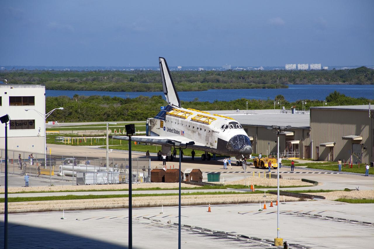 CAPE CANAVERAL, Fla. -- At NASA's Kennedy Space Center in Florida, space shuttle Discovery -- its nose encased in protective plastic, its cockpit windows covered, and strongbacks attached to its payload bay doors -- rolls past the Thermal Protection System Facility, at right, on its way from Orbiter Processing Facility-2, or OPF-2, to the Vehicle Assembly Building, or VAB. Discovery will be stored inside the VAB for approximately one month while shuttle Atlantis undergoes processing in OPF-2 following its final mission, STS-135. Discovery flew its 39th and final mission, STS-133, in February and March 2011, and currently is being prepared for public display at the Smithsonian's National Air and Space Museum Steven F. Udvar-Hazy Center in Virginia. For more information about Discovery's Transition and Retirement, visit www.nasa.gov/mission_pages/shuttle/launch/discovery_rss_collection_archive_1.html. Photo credit: NASA/Jim Grossmann