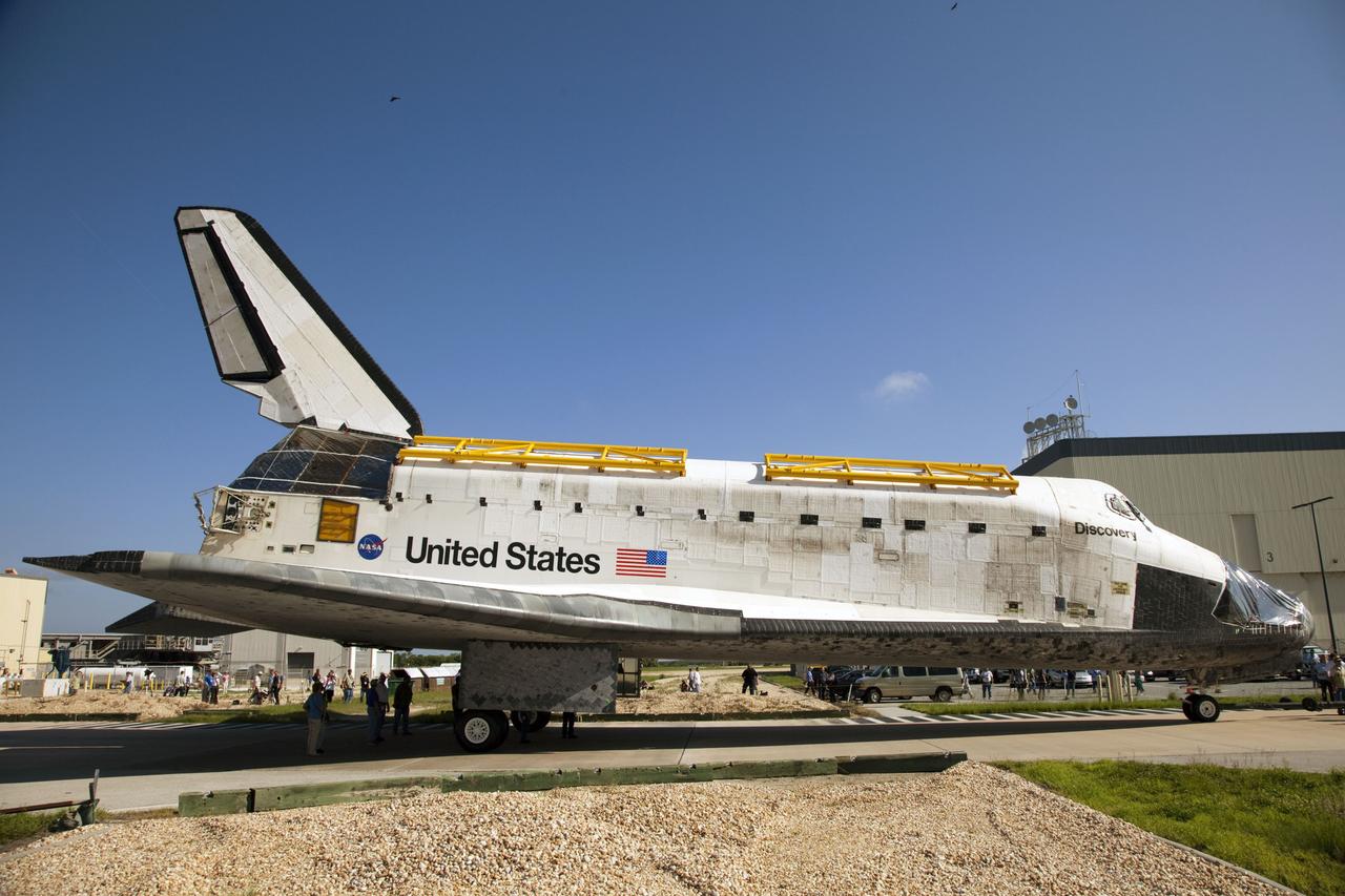 CAPE CANAVERAL, Fla. -- At NASA's Kennedy Space Center in Florida, space shuttle Discovery -- its nose encased in protective plastic, its cockpit windows covered, and strongbacks attached to its payload bay doors -- rolls past Orbiter Processing Facility-3, or OPF-3, at right, on its way from OPF-2 to the Vehicle Assembly Building, or VAB. Discovery will be stored inside the VAB for approximately one month while shuttle Atlantis undergoes processing in OPF-2 following its final mission, STS-135. Discovery flew its 39th and final mission, STS-133, in February and March 2011, and currently is being prepared for public display at the Smithsonian's National Air and Space Museum Steven F. Udvar-Hazy Center in Virginia. For more information about Discovery's Transition and Retirement, visit www.nasa.gov/mission_pages/shuttle/launch/discovery_rss_collection_archive_1.html. Photo credit: NASA/Frankie Martin