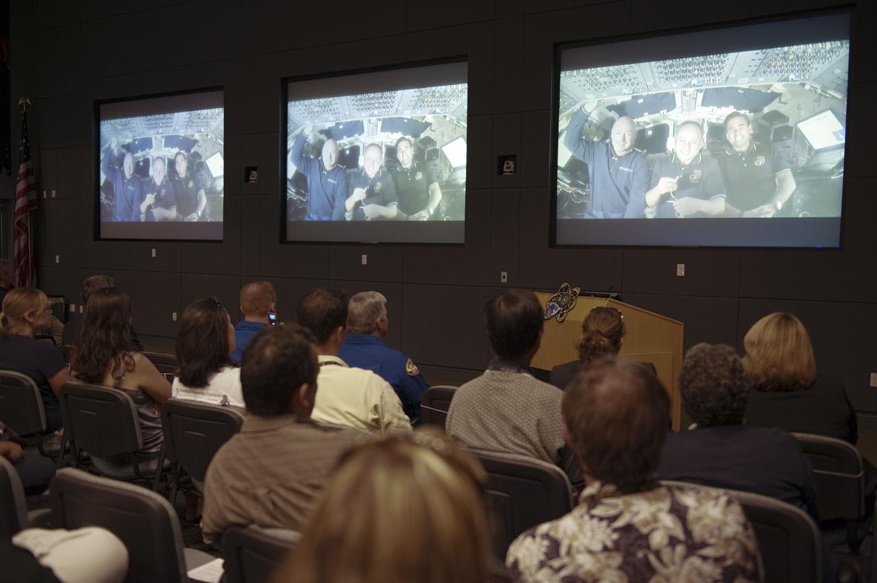 CAPE CANAVERAL, Fla. - Employees at NASA's Kennedy Space Center in Florida are joined by STS-134 Pilot Gregory H. Johnson and Mission Specialist Michael Fincke for a video presentation during a crew return event highlighting the flight.     Commander Mark Kelly, Johnson and Mission Specialists Fincke, Greg Chamitoff, Andrew Feustel and European Space Agency astronaut Roberto Vittori lifted off May 16, 2011, aboard space shuttle Endeavour. During the nearly 16-day STS-134 mission, Endeavour delivered to the International Space Station the Alpha Magnetic Spectrometer (AMS) and spare parts, including two S-band communications antennas, a high-pressure gas tank and additional spare parts for Dextre. This was the 36th shuttle mission to the station and Endeavour's 25th and final flight.  For more information, visit www.nasa.gov/mission_pages/shuttle/shuttlemissions/sts134/main/index.html.  Photo credit: NASA/Kim Shiflett