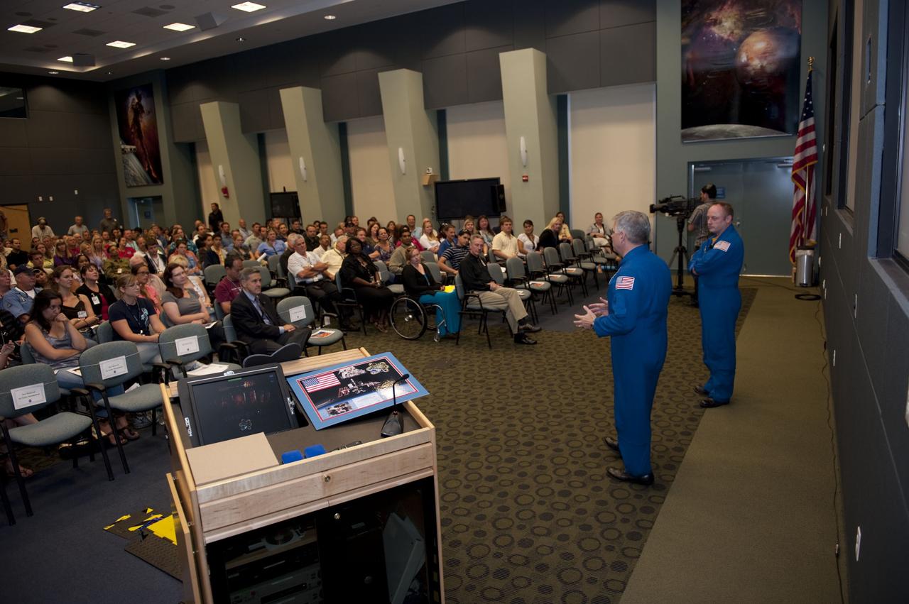 CAPE CANAVERAL, Fla. - In an auditorium packed with employees at NASA's Kennedy Space Center in Florida, STS-134 Pilot Gregory H. Johnson, left, and Mission Specialist Michael Fincke relate stories from their mission. The gathering is part of a crew return event at Kennedy.    Commander Mark Kelly, Johnson and Mission Specialists Fincke, Greg Chamitoff, Andrew Feustel and European Space Agency astronaut Roberto Vittori lifted off May 16, 2011, aboard space shuttle Endeavour. During the nearly 16-day STS-134 mission, Endeavour delivered to the International Space Station the Alpha Magnetic Spectrometer (AMS) and spare parts, including two S-band communications antennas, a high-pressure gas tank and additional spare parts for Dextre. This was the 36th shuttle mission to the station and Endeavour's 25th and final flight.  For more information, visit www.nasa.gov/mission_pages/shuttle/shuttlemissions/sts134/main/index.html.  Photo credit: NASA/Kim Shiflett