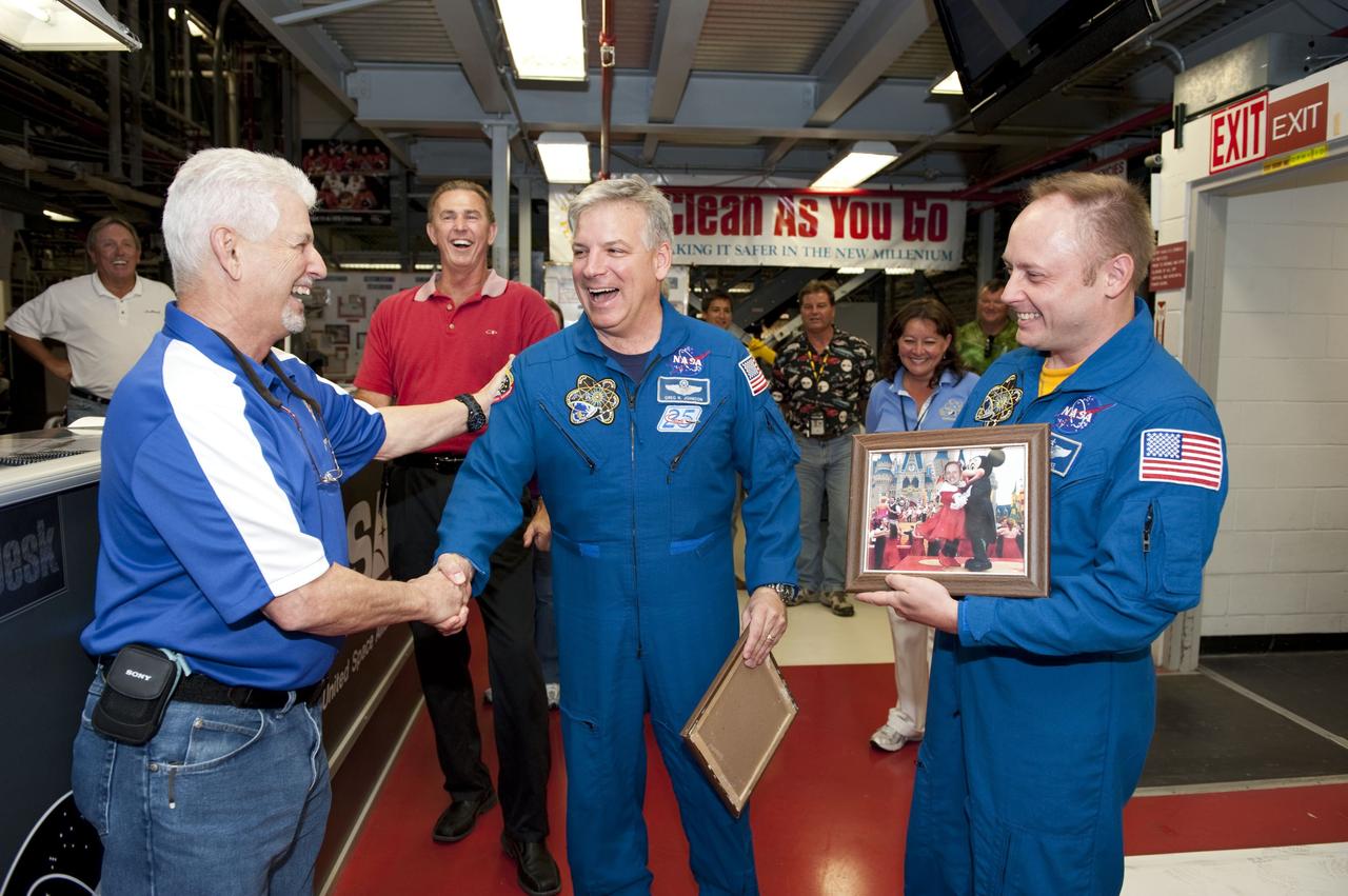 CAPE CANAVERAL, Fla. - Walter "Buddy" McKenzie shakes hands with STS-134 Pilot Gregory H. Johnson as Mission Specialist Michael Fincke, right, looks on. The astronauts visited with employees inside NASA Kennedy Space Center's Orbiter Processing Facility-1, where space shuttle Endeavour is being prepared for public display. Commander Mark Kelly, Johnson and Mission Specialists Fincke, Greg Chamitoff, Andrew Feustel and European Space Agency astronaut Roberto Vittori lifted off May 16, 2011 aboard space shuttle Endeavour. During the nearly 16-day STS-134 mission, Endeavour delivered to the International Space Station the Alpha Magnetic Spectrometer (AMS) and spare parts, including two S-band communications antennas, a high-pressure gas tank and additional spare parts for Dextre. This was the 36th shuttle mission to the station and Endeavour's 25th and final flight. For more information, visit www.nasa.gov/mission_pages/shuttle/shuttlemissions/sts134/main/index.html. Photo credit: NASA/Kim Shiflett