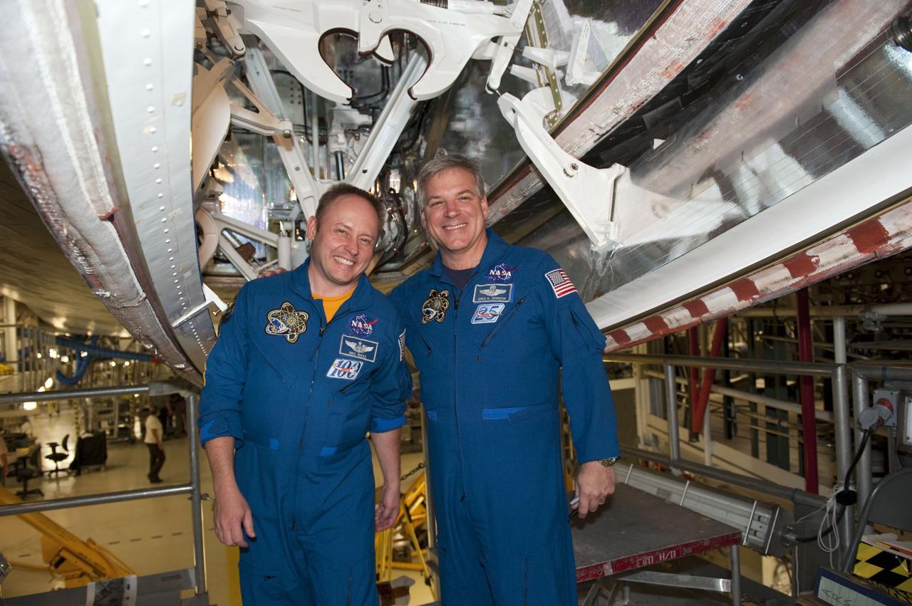 CAPE CANAVERAL, Fla. - STS-134 Mission Specialist Michael Fincke, left, and Pilot Gregory H. Johnson pose in front of space shuttle Endeavour's landing gear inside NASA Kennedy Space Center's Orbiter Processing Facility-1 following a crew return event. Commander Mark Kelly, Johnson and Mission Specialists Fincke, Greg Chamitoff, Andrew Feustel and European Space Agency astronaut Roberto Vittori lifted off May 16, 2011 aboard space shuttle Endeavour. During the nearly 16-day STS-134 mission, Endeavour delivered to the International Space Station the Alpha Magnetic Spectrometer (AMS) and spare parts, including two S-band communications antennas, a high-pressure gas tank and additional spare parts for Dextre. This was the 36th shuttle mission to the station and Endeavour's 25th and final flight. For more information, visit www.nasa.gov/mission_pages/shuttle/shuttlemissions/sts134/main/index.html. Photo credit: NASA/Kim Shiflett