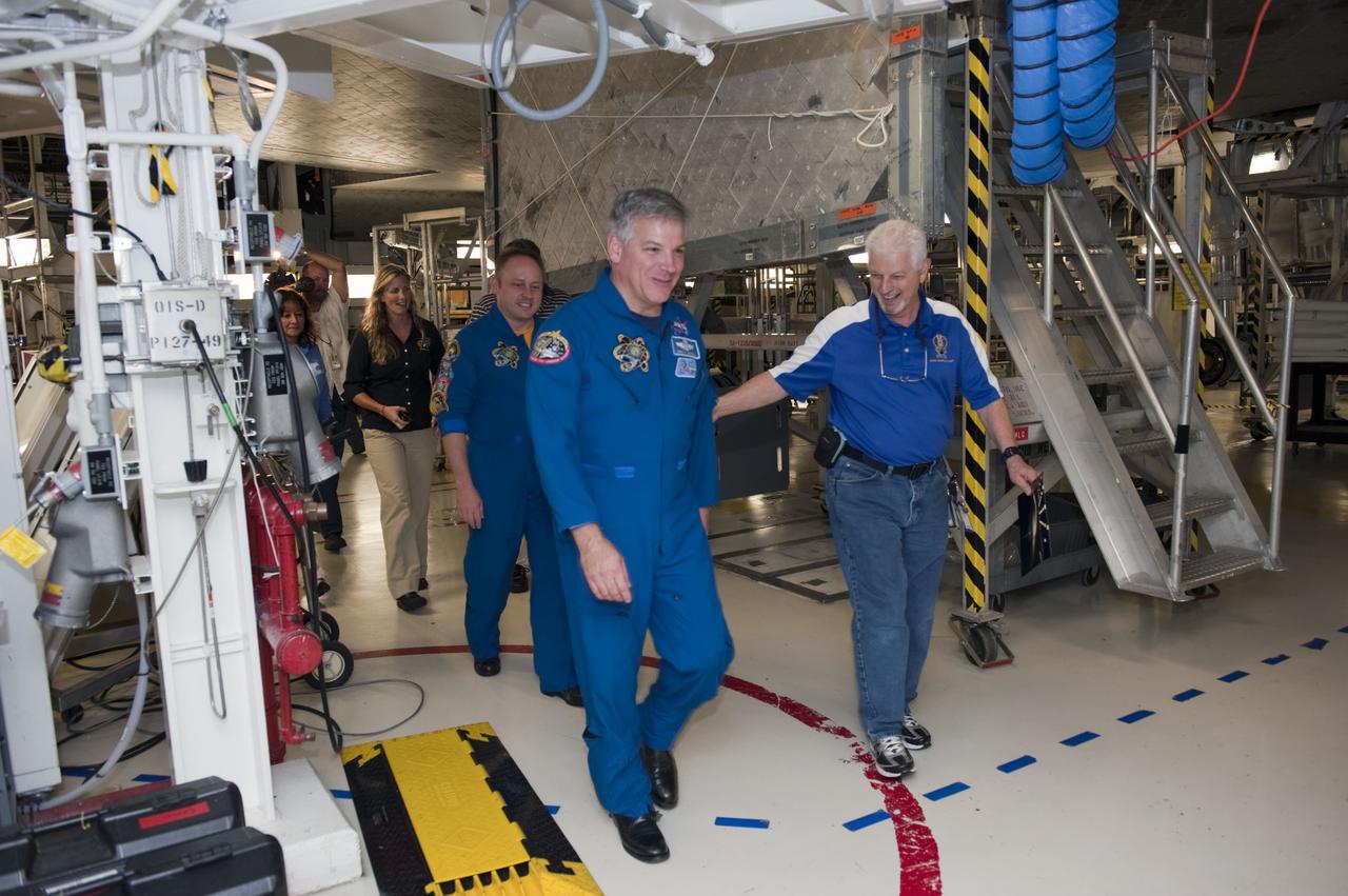 CAPE CANAVERAL, Fla. - Walter "Buddy" McKenzie leads STS-134 Pilot Gregory H. Johnson, foreground, Mission Specialist Michael Fincke, space shuttle Endeavour Flow Director Dana Hutcherson and others through Orbiter Processing Facility-1 following a crew return event. Commander Mark Kelly, Johnson and Mission Specialists Fincke, Greg Chamitoff, Andrew Feustel and European Space Agency astronaut Roberto Vittori lifted off May 16, 2011 aboard space shuttle Endeavour. During the nearly 16-day STS-134 mission, Endeavour delivered to the International Space Station the Alpha Magnetic Spectrometer (AMS) and spare parts, including two S-band communications antennas, a high-pressure gas tank and additional spare parts for Dextre. This was the 36th shuttle mission to the station and Endeavour's 25th and final flight. For more information, visit www.nasa.gov/mission_pages/shuttle/shuttlemissions/sts134/main/index.html. Photo credit: NASA/Kim Shiflett