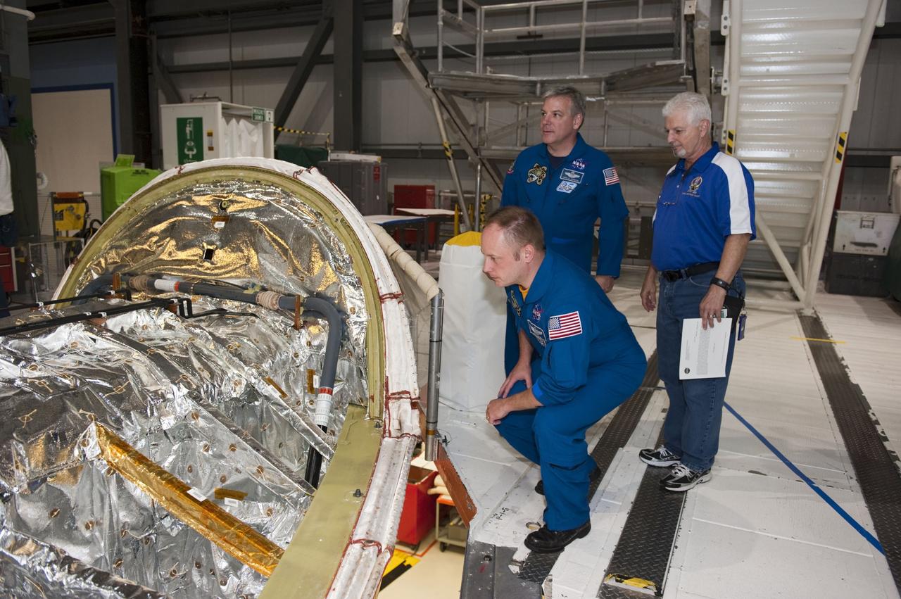 CAPE CANAVERAL, Fla. - STS-134 Mission Specialist Michael Fincke, foreground, and Pilot Gregory H. Johnson are joined by Walter "Buddy" McKenzie as the astronauts get a close look at space shuttle Endeavour inside NASA Kennedy Space Center's Orbiter Processing Facility-1. The spacecraft is being prepared for public display. Commander Mark Kelly, Johnson and Mission Specialists Fincke, Greg Chamitoff, Andrew Feustel and European Space Agency astronaut Roberto Vittori lifted off May 16, 2011 aboard space shuttle Endeavour. During the nearly 16-day STS-134 mission, Endeavour delivered to the International Space Station the Alpha Magnetic Spectrometer (AMS) and spare parts, including two S-band communications antennas, a high-pressure gas tank and additional spare parts for Dextre. This was the 36th shuttle mission to the station and Endeavour's 25th and final flight. For more information, visit www.nasa.gov/mission_pages/shuttle/shuttlemissions/sts134/main/index.html. Photo credit: NASA/Kim Shiflett