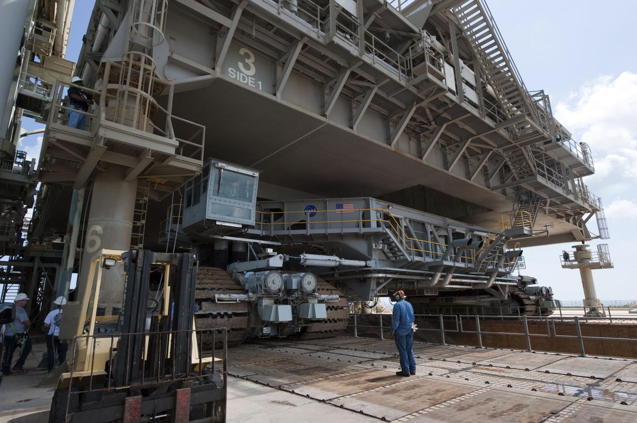 CAPE CANAVERAL, Fla. -- At NASA's Kennedy Space Center in Florida, Mobile Launcher Platform-3 (MLP), which supported space shuttle Atlantis for its final flight to the International Space Station on the STS-135 mission, is being prepared for its last journey from Launch Pad 39A to the Vehicle Assembly Building (VAB). Here, workers check the position of the massive crawler-transporter positioned under the MLP -- the last mobile launcher platform to launch a shuttle.                   For more than 40 years, the MLPs have traveled between the massive VAB to both launch pads at Launch Complex 39, and then returned to the VAB for future use. MLP-3 was first used to launch Columbia on the STS-32 mission on Jan. 9, 1990. Photo credit: NASA/Kim Shiflett