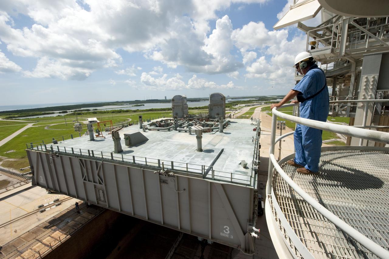 CAPE CANAVERAL, Fla. -- At NASA's Kennedy Space Center in Florida, Mobile Launcher Platform-3 (MLP), which supported space shuttle Atlantis for its final flight to the International Space Station on the STS-135 mission, is taking its last journey from Launch Pad 39A to the Vehicle Assembly Building (VAB). Here, workers monitor the process as a massive crawler-transporter positioned under the MLP, the last mobile launcher platform to launch a shuttle, begins its trek back to the VAB.                 For more than 40 years, the MLPs have traveled between the massive VAB to both launch pads at Launch Complex 39, and then returned to the VAB for future use. MLP-3 was first used to launch Columbia on the STS-32 mission on Jan. 9, 1990. Photo credit: NASA/Kim Shiflett