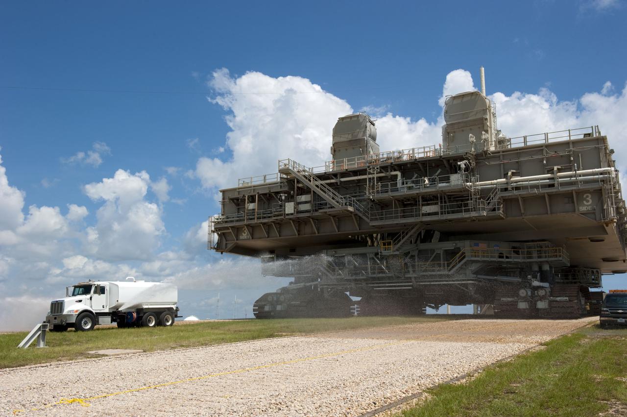 CAPE CANAVERAL, Fla. -- At NASA's Kennedy Space Center in Florida, Mobile Launcher Platform-3 (MLP), which supported space shuttle Atlantis for its final flight to the International Space Station on the STS-135 mission, is taking its last journey from Launch Pad 39A to the Vehicle Assembly Building (VAB). A massive crawler-transporter positioned under the MLP -- the last mobile launcher platform to launch a shuttle, begins the trek back to the VAB. A water truck leads the way spraying water on the dry crawlerway to reduce dust particles in the air.                     For more than 40 years, the MLPs have traveled between the massive VAB to both launch pads at Launch Complex 39, and then returned to the VAB for future use. MLP-3 was first used to launch Columbia on the STS-32 mission on Jan. 9, 1990. Photo credit: NASA/Kim Shiflett