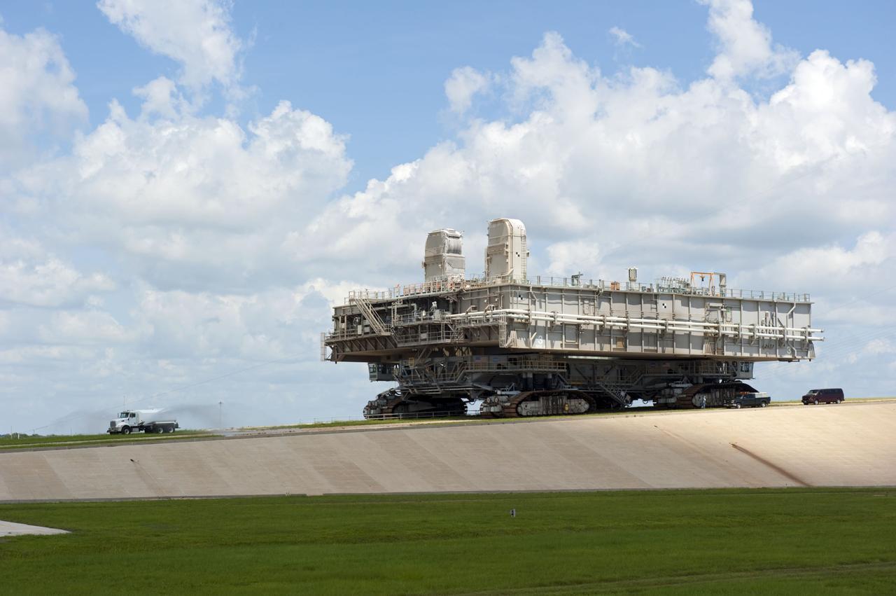 CAPE CANAVERAL, Fla. -- At NASA's Kennedy Space Center in Florida, Mobile Launcher Platform-3 (MLP), which supported space shuttle Atlantis for its final flight to the International Space Station on the STS-135 mission, is taking its last journey from Launch Pad 39A to the Vehicle Assembly Building (VAB). A massive crawler-transporter positioned under the MLP -- the last mobile launcher platform to launch a shuttle, begins the trek back to the VAB. A water truck leads the way spraying water on the dry crawlerway to reduce dust particles in the air.                     For more than 40 years, the MLPs have traveled between the massive VAB to both launch pads at Launch Complex 39, and then returned to the VAB for future use. MLP-3 was first used to launch Columbia on the STS-32 mission on Jan. 9, 1990. Photo credit: NASA/Kim Shiflett