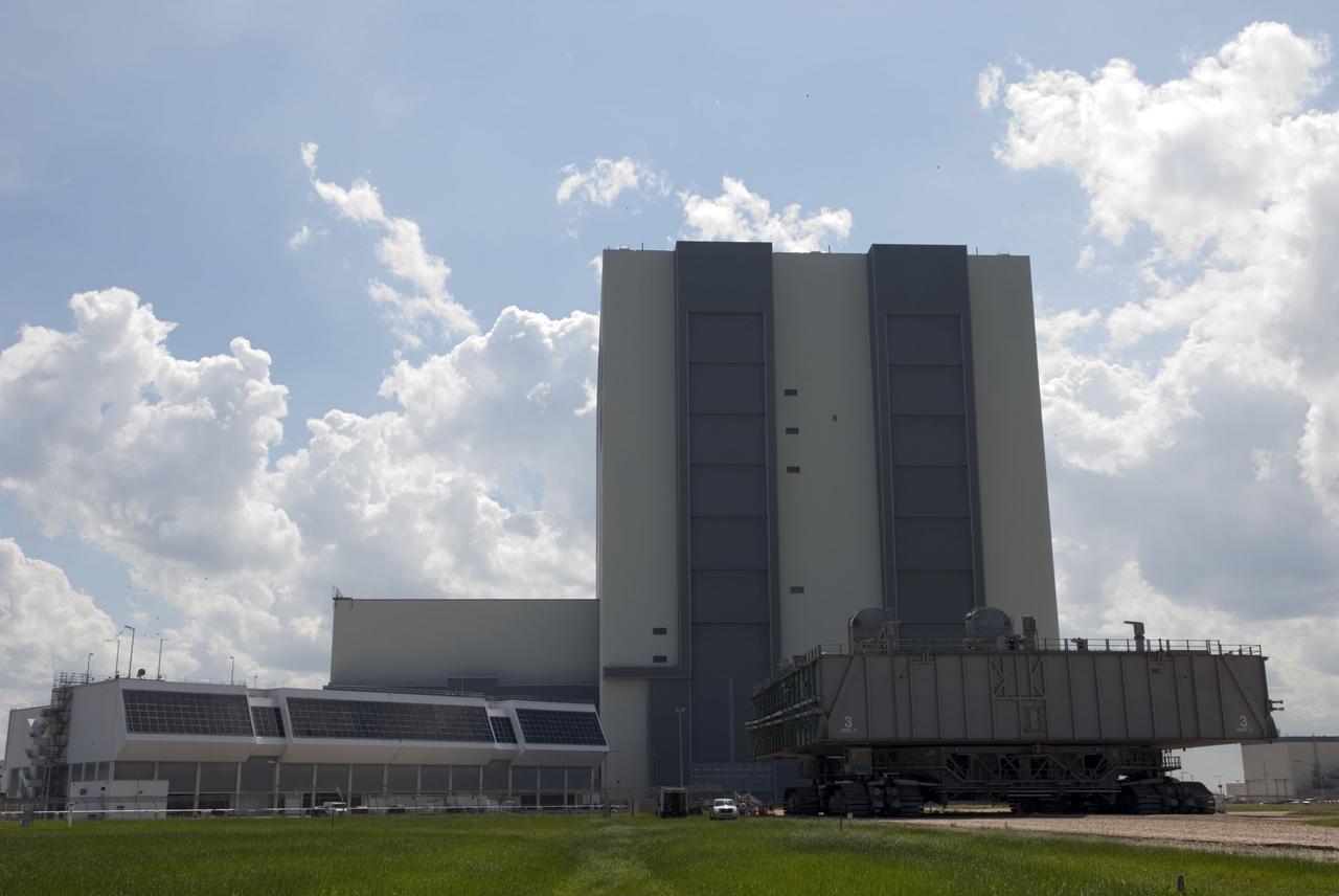 CAPE CANAVERAL, Fla. -- At NASA's Kennedy Space Center in Florida, Mobile Launcher Platform-3 (MLP), which supported space shuttle Atlantis for its final flight to the International Space Station on the STS-135 mission, is making its last journey from Launch Pad 39A into the Vehicle Assembly Building (VAB) atop a massive crawler-transporter. Seen also is the Space Shuttle Program's Launch Control Center (left).        For more than 40 years, the MLPs have traveled between the VAB to both launch pads at Launch Complex 39, and then returned to the VAB for future use. MLP-3 was first used to launch Columbia on the STS-32 mission on Jan. 9, 1990. Photo credit: NASA/Jim Grossmann