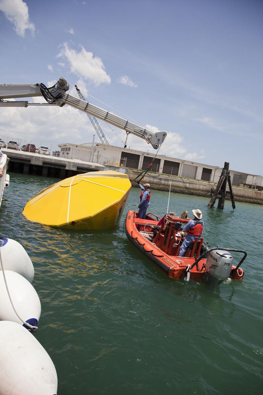 CAPE CANAVERAL, Fla. -- In the Delta turn basin at Cape Canaveral Air Force Station in Florida,  United Space Alliance (USA) workers help orient an Orion test article to enable a ship's crane to rotate it.     The uprighting tests are part of USA's research and development program to help develop ground operations support equipment that could be used to reorient and recover an uncrewed Orion flight test capsule after splashdown.  USA is a major subcontractor to Lockheed Martin for the Orion spacecraft. The Orion Multi-Purpose Crew Vehicle is NASA's next-generation spacecraft designed for deep space missions to asteroids, moons and other interplanetary destinations throughout the solar system. Orion's first uncrewed orbital flight test is slated for 2013. For more information, visit http://www.nasa.gov/exploration/systems/mpcv/. Photo credit: NASA/Frankie Martin