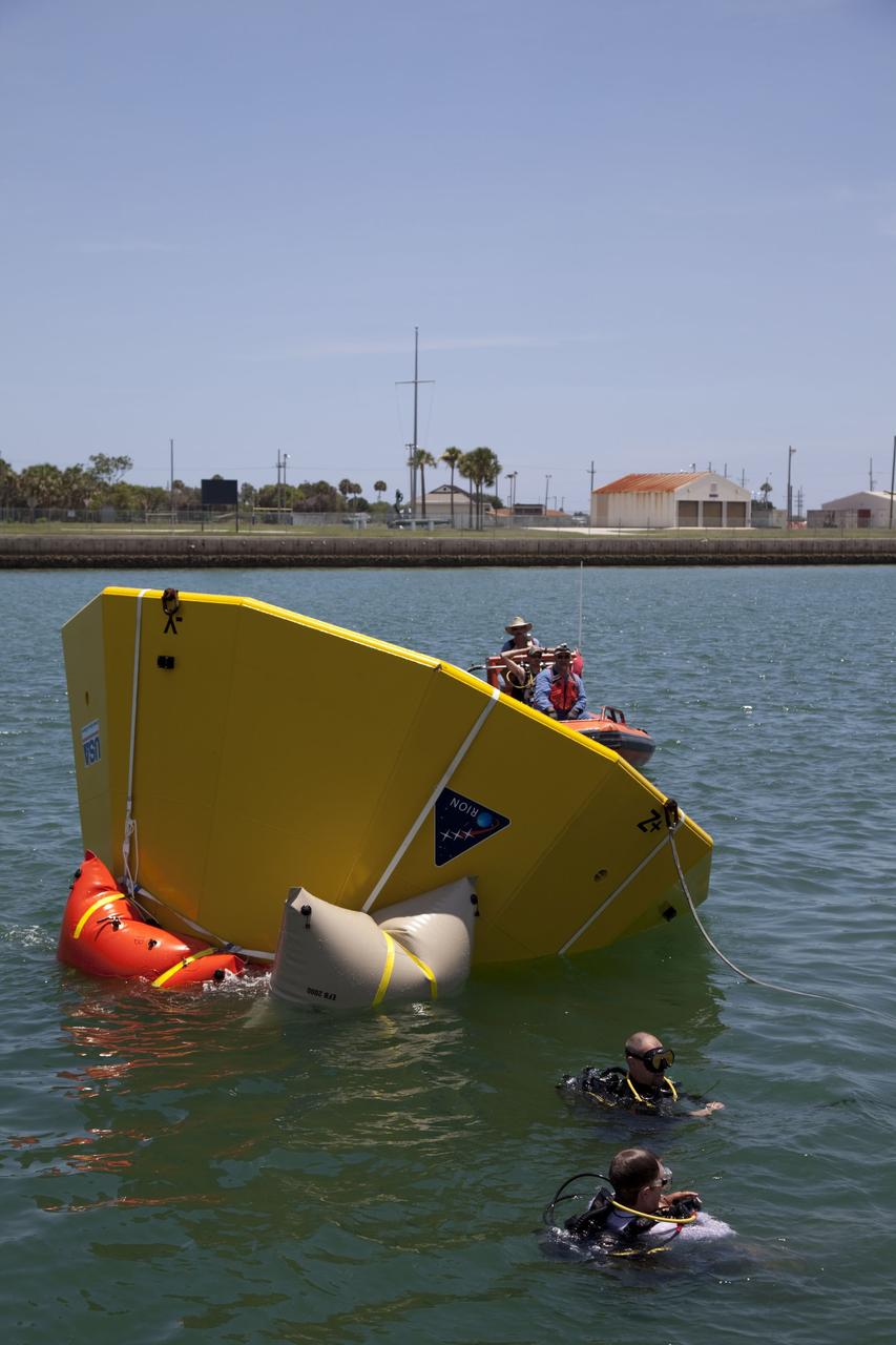CAPE CANAVERAL, Fla. -- In the Delta turn basin at Cape Canaveral Air Force Station in Florida, United Space Alliance (USA) divers and boat crew tend an Orion test article while waiting for its lift bags to inflate. The uprighting tests are part of USA's research and development program to help develop ground operations support equipment that could be used to reorient and recover an uncrewed Orion flight test capsule after splashdown. USA is a major subcontractor to Lockheed Martin for the Orion spacecraft. The Orion Multi-Purpose Crew Vehicle is NASA's next-generation spacecraft designed for deep space missions to asteroids, moons and other interplanetary destinations throughout the solar system. Orion's first uncrewed orbital flight test is slated for 2013. For more information, visit http://www.nasa.gov/exploration/systems/mpcv/. Photo credit: NASA/Frankie Martin