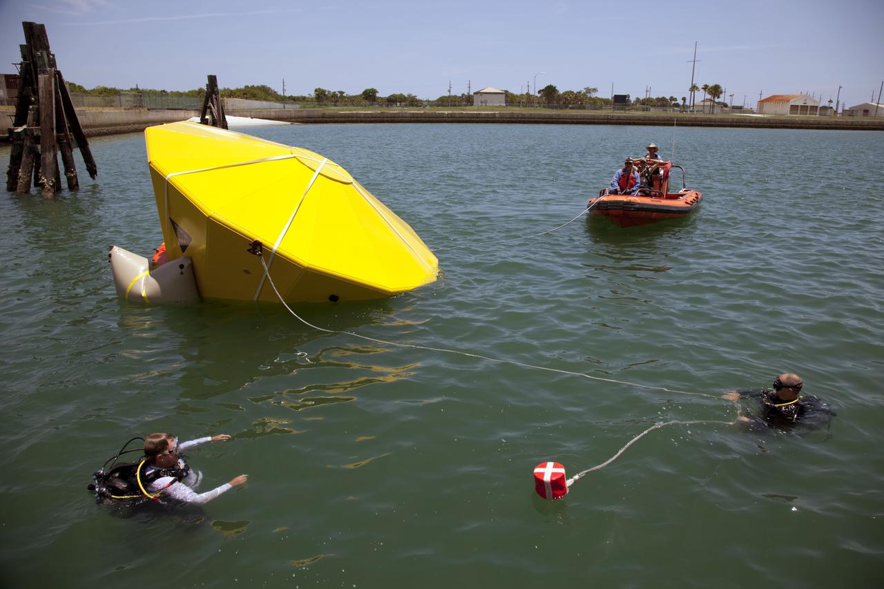 CAPE CANAVERAL, Fla. -- In the Delta turn basin at Cape Canaveral Air Force Station in Florida, United Space Alliance (USA) divers and boat crew monitor an Orion test article while waiting for its lift bags to inflate. The uprighting tests are part of USA's research and development program to help develop ground operations support equipment that could be used to reorient and recover an uncrewed Orion flight test capsule after splashdown. USA is a major subcontractor to Lockheed Martin for the Orion spacecraft. The Orion Multi-Purpose Crew Vehicle is NASA's next-generation spacecraft designed for deep space missions to asteroids, moons and other interplanetary destinations throughout the solar system. Orion's first uncrewed orbital flight test is slated for 2013. For more information, visit http://www.nasa.gov/exploration/systems/mpcv/. Photo credit: NASA/Frankie Martin