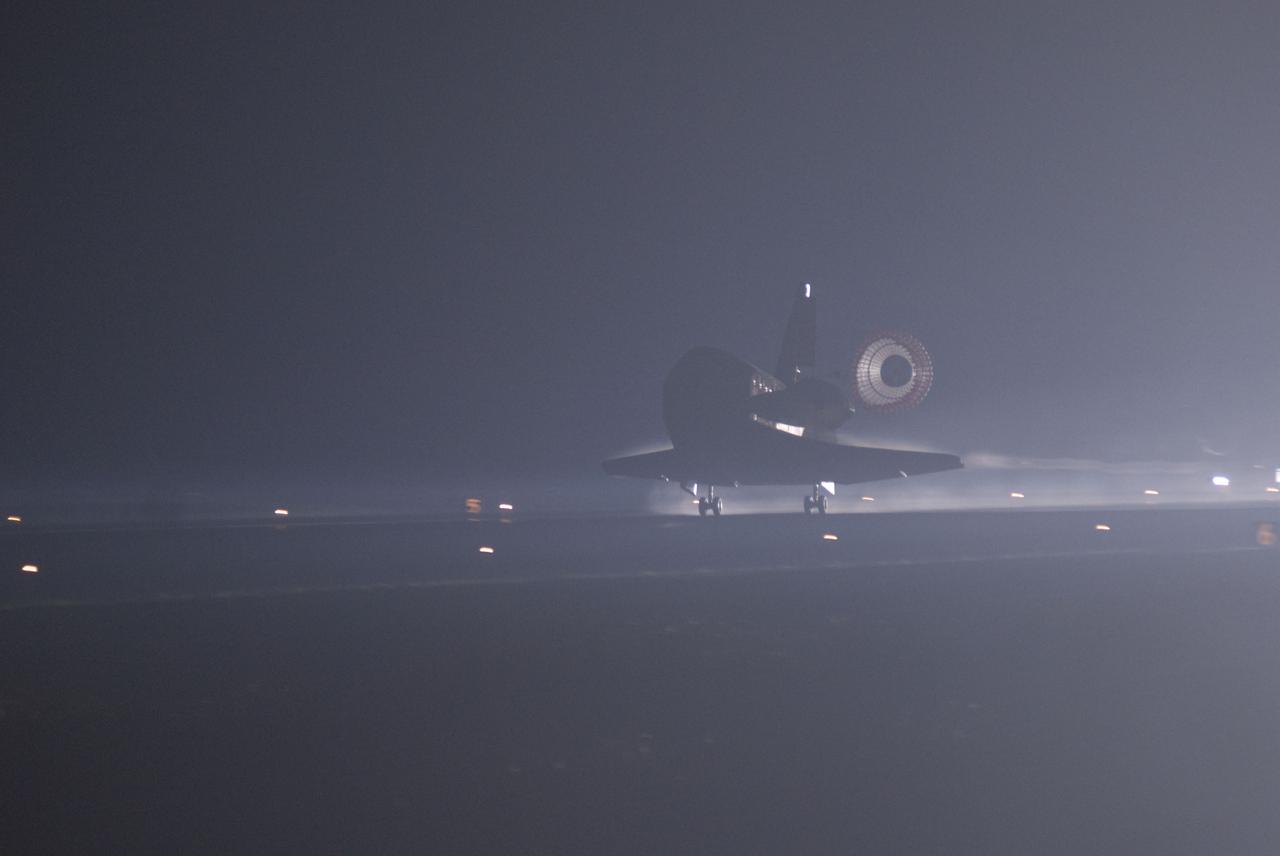 CAPE CANAVERAL, Fla. -- Xenon lights illuminate space shuttle Atlantis' unfurled drag chute as the vehicle rolls to a stop on the Shuttle Landing Facility's Runway 15 at NASA's Kennedy Space Center in Florida for the final. Securing the space shuttle fleet's place in history, Atlantis marked the 26th nighttime landing of NASA's Space Shuttle Program and the 78th landing at Kennedy. Main gear touchdown was at 5:57:00 a.m. EDT, followed by nose gear touchdown at 5:57:20 a.m., and wheelstop at 5:57:54 a.m. On board are STS-135 Commander Chris Ferguson, Pilot Doug Hurley, and Mission Specialists Sandra Magnus and Rex Walheim.      On the 37th shuttle mission to the International Space Station, STS-135 delivered more than 9,400 pounds of spare parts, equipment and supplies in the Raffaello multi-purpose logistics module that will sustain station operations for the next year. STS-135 was the 33rd and final flight for Atlantis, which has spent 307 days in space, orbited Earth 4,848 times and traveled 125,935,769 miles. For more information visit, www.nasa.gov/mission_pages/shuttle/shuttlemissions/sts135/index.html. Photo credit: NASA/Jim Grossmann