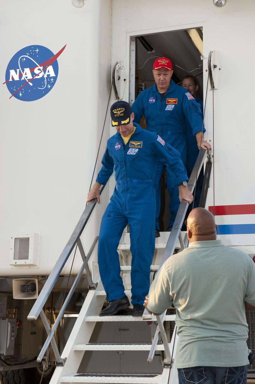 CAPE CANAVERAL, Fla. -- STS-135 Commander Chris Ferguson leads his crew out of the Crew Transport Vehicle (CTV) following brief and standard medical checks. Behind Ferguson is Pilot Doug Hurley. Four astronauts brought space shuttle Atlantis home to the Shuttle Landing Facility's Runway 15 at NASA's Kennedy Space Center in Florida at 5:57 a.m. EDT bringing a close NASA's Space Shuttle Program. Atlantis' final return from space completed a 13-day, 5.2-million-mile journey to the International Space Station.                  STS-135 delivered spare parts, equipment and supplies in the Raffaello multi-purpose logistics module that will sustain station operations for the next year. STS-135 was the 33rd and final flight for Atlantis, which has spent 307 days in space, orbited Earth 4,848 times and traveled 125,935,769 miles. For more information visit, www.nasa.gov/mission_pages/shuttle/shuttlemissions/sts135/index.html. Photo credit: NASA/Kim Shiflett
