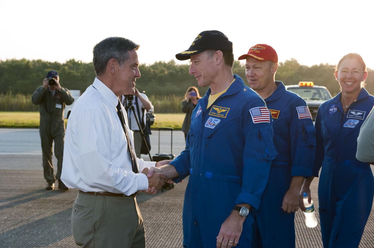 CAPE CANAVERAL, Fla. -- NASA Kennedy Space Center Director Bob Cabana, left, congratulates STS-135 Commander Chris Ferguson on the successful STS-135 mission to the International Space Station. Behind Ferguson are Pilot Doug Hurley and Mission Specialist Sandy Magnus. Ferguson and his three crew members safely brought space shuttle Atlantis home to the Shuttle Landing Facility's Runway 15 at NASA's Kennedy Space Center in Florida at 5:57 a.m. EDT bringing a close NASA's Space Shuttle Program. Atlantis' final return from space completed a 13-day, 5.2-million-mile journey to the International Space Station.             STS-135 delivered spare parts, equipment and supplies in the Raffaello multi-purpose logistics module that will sustain station operations for the next year. STS-135 was the 33rd and final flight for Atlantis, which has spent 307 days in space, orbited Earth 4,848 times and traveled 125,935,769 miles. For more information visit, www.nasa.gov/mission_pages/shuttle/shuttlemissions/sts135/index.html. Photo credit: NASA/Kim Shiflett