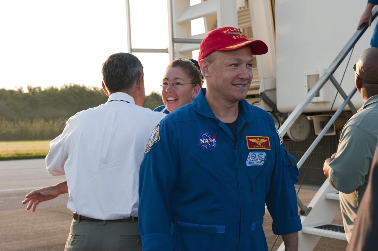 CAPE CANAVERAL, Fla. -- NASA Kennedy Space Center Director Bob Cabana, left, congratulates STS-135 Mission Specialist Sandy Magnus on the successful STS-135 mission to the International Space Station. In front of Magnus is Pilot Doug Hurley. Magnus and her three crew members brought space shuttle Atlantis home to the Shuttle Landing Facility's Runway 15 at NASA's Kennedy Space Center in Florida at 5:57 a.m. EDT bringing a close NASA's Space Shuttle Program. Atlantis' final return from space completed a 13-day, 5.2-million-mile journey to the International Space Station.           STS-135 delivered spare parts, equipment and supplies in the Raffaello multi-purpose logistics module that will sustain station operations for the next year. STS-135 was the 33rd and final flight for Atlantis, which has spent 307 days in space, orbited Earth 4,848 times and traveled 125,935,769 miles. For more information visit, www.nasa.gov/mission_pages/shuttle/shuttlemissions/sts135/index.html. Photo credit: NASA/Kim Shiflett