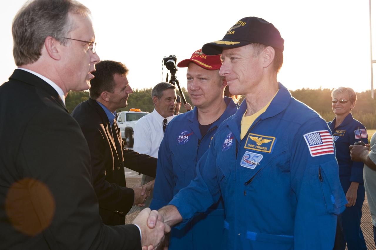 CAPE CANAVERAL, Fla. -- STS-135 Commander Chris Ferguson, front right, and Pilot Doug Hurley are congratulated by Space Shuttle Program Manager John Shannon, front left, Space Shuttle Program Deputy Manager LeRoy Cain, and NASA Kennedy Space Center Director Bob Cabana on their successful mission to the International Space Station. Four astronauts brought space shuttle Atlantis home to the Shuttle Landing Facility's Runway 15 at NASA's Kennedy Space Center in Florida at 5:57 a.m. EDT bringing a close NASA's Space Shuttle Program. Atlantis' final return from space completed a 13-day, 5.2-million-mile journey to the International Space Station.            STS-135 delivered spare parts, equipment and supplies in the Raffaello multi-purpose logistics module that will sustain station operations for the next year. STS-135 was the 33rd and final flight for Atlantis, which has spent 307 days in space, orbited Earth 4,848 times and traveled 125,935,769 miles. For more information visit, www.nasa.gov/mission_pages/shuttle/shuttlemissions/sts135/index.html. Photo credit: NASA/Kim Shiflett