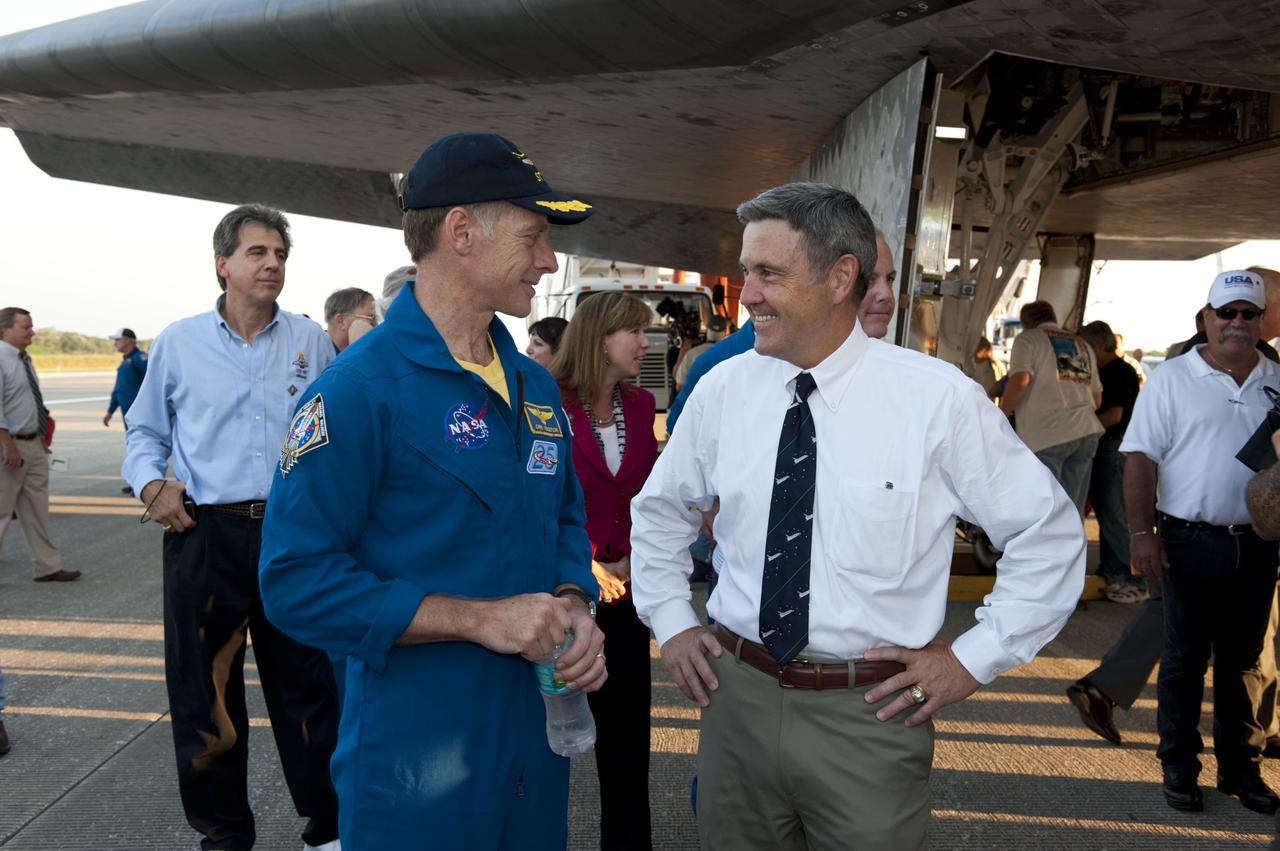 CAPE CANAVERAL, Fla. -- STS-135 Commander Chris Ferguson, left, and NASA Kennedy Space Center Director Bob Cabana talk about the successful STS-135 mission to the International Space Station. Behind Ferguson are Pilot Doug Hurley and Mission Specialist Sandy Magnus. Ferguson and his three crew members safely brought space shuttle Atlantis home to the Shuttle Landing Facility's Runway 15 at NASA's Kennedy Space Center in Florida at 5:57 a.m. EDT bringing a close NASA's Space Shuttle Program. Atlantis' final return from space completed a 13-day, 5.2-million-mile journey to the International Space Station.              STS-135 delivered spare parts, equipment and supplies in the Raffaello multi-purpose logistics module that will sustain station operations for the next year. STS-135 was the 33rd and final flight for Atlantis, which has spent 307 days in space, orbited Earth 4,848 times and traveled 125,935,769 miles. For more information visit, www.nasa.gov/mission_pages/shuttle/shuttlemissions/sts135/index.html. Photo credit: NASA/Kim Shiflett
