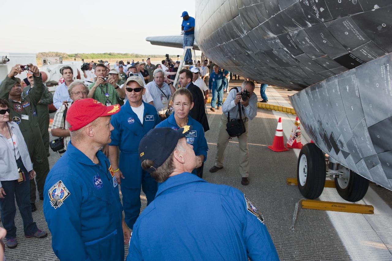 CAPE CANAVERAL, Fla. -- The STS-135 crew admires space shuttle Atlantis following the successful mission to the International Space Station. Four astronauts brought Atlantis home to the Shuttle Landing Facility's Runway 15 at NASA's Kennedy Space Center in Florida at 5:57 a.m. EDT bringing a close NASA's Space Shuttle Program. Atlantis' final return from space completed a 13-day, 5.2-million-mile journey to the International Space Station.            STS-135 delivered spare parts, equipment and supplies in the Raffaello multi-purpose logistics module that will sustain station operations for the next year. STS-135 was the 33rd and final flight for Atlantis, which has spent 307 days in space, orbited Earth 4,848 times and traveled 125,935,769 miles. For more information visit, www.nasa.gov/mission_pages/shuttle/shuttlemissions/sts135/index.html. Photo credit: NASA/Kim Shiflett