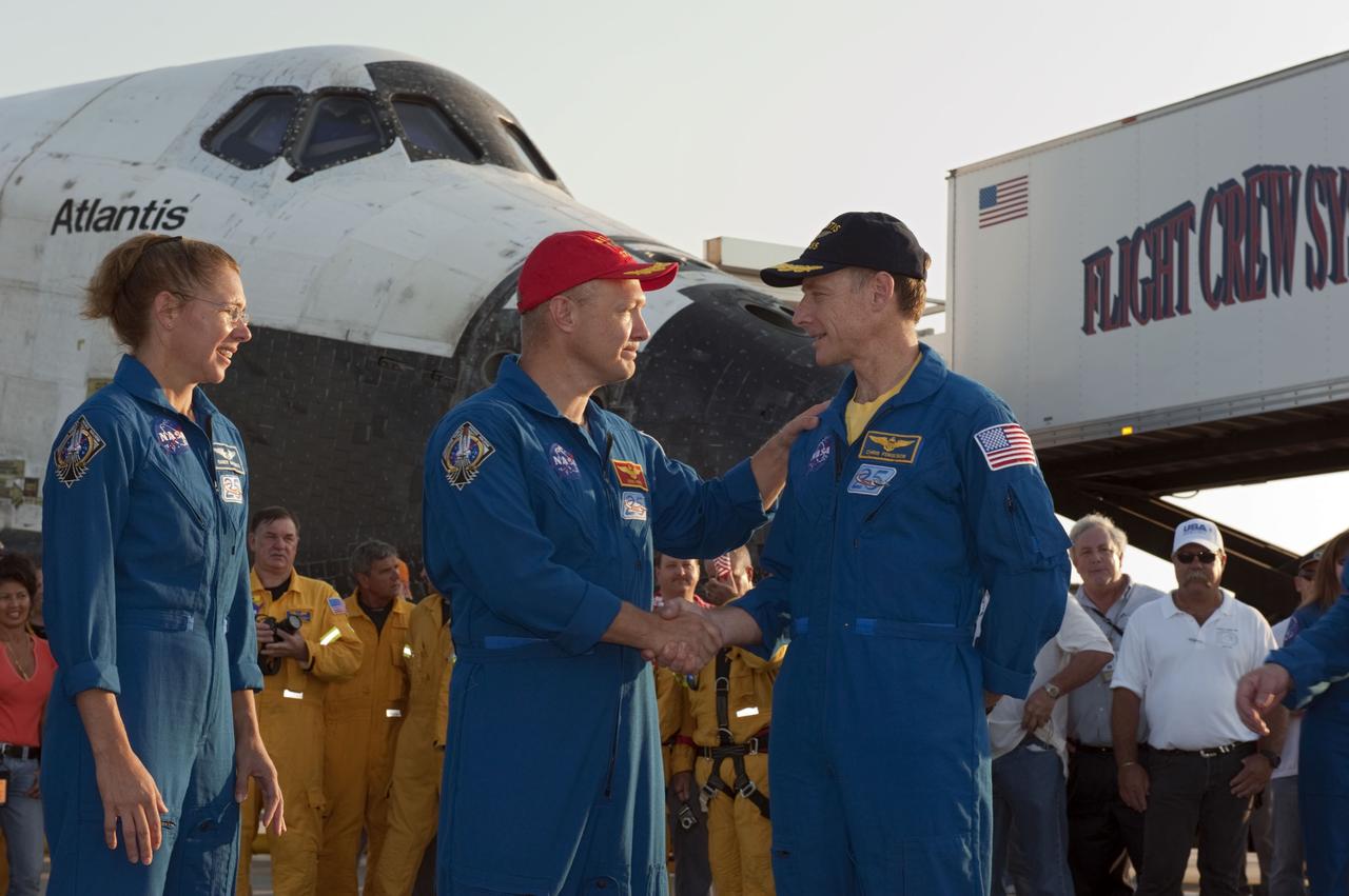 CAPE CANAVERAL, Fla. -- The final astronauts of NASA's Space Shuttle Program reflect on their successful STS-135 mission to the International Space Station in front of space shuttle Atlantis. From left, are Mission Specialist Sandy Magnus, Pilot Doug Hurley and Commander Chris Ferguson. Four astronauts returned to Earth on the Shuttle Landing Facility's Runway 15 at NASA's Kennedy Space Center in Florida at 5:57 a.m. EDT. Atlantis' final return from space completed a 13-day, 5.2-million-mile journey to the International Space Station.          STS-135 delivered spare parts, equipment and supplies in the Raffaello multi-purpose logistics module that will sustain station operations for the next year. STS-135 was the 33rd and final flight for Atlantis, which has spent 307 days in space, orbited Earth 4,848 times and traveled 125,935,769 miles. For more information visit, www.nasa.gov/mission_pages/shuttle/shuttlemissions/sts135/index.html. Photo credit: NASA/Kim Shiflett