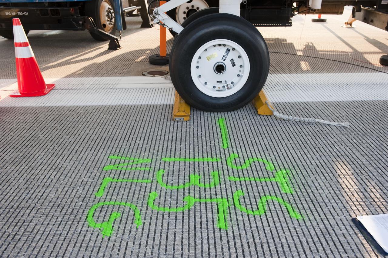 CAPE CANAVERAL, Fla. -- Workers measured and marked in bright green the letters "NLG" at the spot where space shuttle Atlantis' nose landing gear came to a stop after the vehicle's final return from space. Securing the space shuttle fleet's place in history on the STS-135 mission, Atlantis safely and successfully rounded out NASA's Space Shuttle Program on the Shuttle Landing Facility's Runway 15 at Kennedy Space Center in Florida. Main gear touchdown was at 5:57:00 a.m. EDT, followed by nose gear touchdown at 5:57:20 a.m., and wheelstop at 5:57:54 a.m.     On the 37th shuttle mission to the International Space Station, STS-135 delivered more than 9,400 pounds of spare parts, equipment and supplies in the Raffaello multi-purpose logistics module that will sustain station operations for the next year. STS-135 was the 33rd and final flight for Atlantis, which has spent 307 days in space, orbited Earth 4,848 times and traveled 125,935,769 miles. For more information visit, www.nasa.gov/mission_pages/shuttle/shuttlemissions/sts135/index.html. Photo credit: NASA/Kim Shiflett