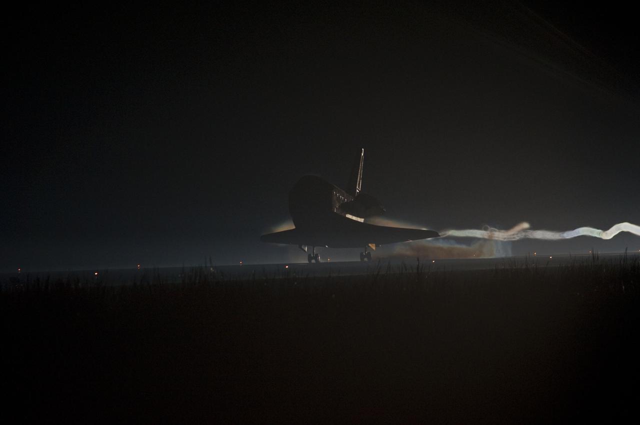 CAPE CANAVERAL, Fla. -- Ribbons of steam and smoke trail space shuttle Atlantis as it touches down for the final time on the Shuttle Landing Facility's Runway 15 at NASA's Kennedy Space Center in Florida. Securing the space shuttle fleet's place in history, Atlantis marked the 26th nighttime landing of NASA's Space Shuttle Program and the 78th landing at Kennedy. Main gear touchdown was at 5:57:00 a.m. EDT, followed by nose gear touchdown at 5:57:20 a.m., and wheelstop at 5:57:54 a.m. On board are STS-135 Commander Chris Ferguson, Pilot Doug Hurley, and Mission Specialists Sandra Magnus and Rex Walheim.    On the 37th shuttle mission to the International Space Station, STS-135 delivered the Raffaello multi-purpose logistics module    filled with more than 9,400 pounds of spare parts, equipment and supplies that will sustain station operations for the next year. STS-135 was the 33rd and final flight for Atlantis, which has spent 307 days in space, orbited Earth 4,848 times and traveled 125,935,769 miles. STS-135 also was the final mission of the Space Shuttle Program.  For more information, visit www.nasa.gov/mission_pages/shuttle/shuttlemissions/sts135/index.html. Photo credit: NASA/Chad Baumer