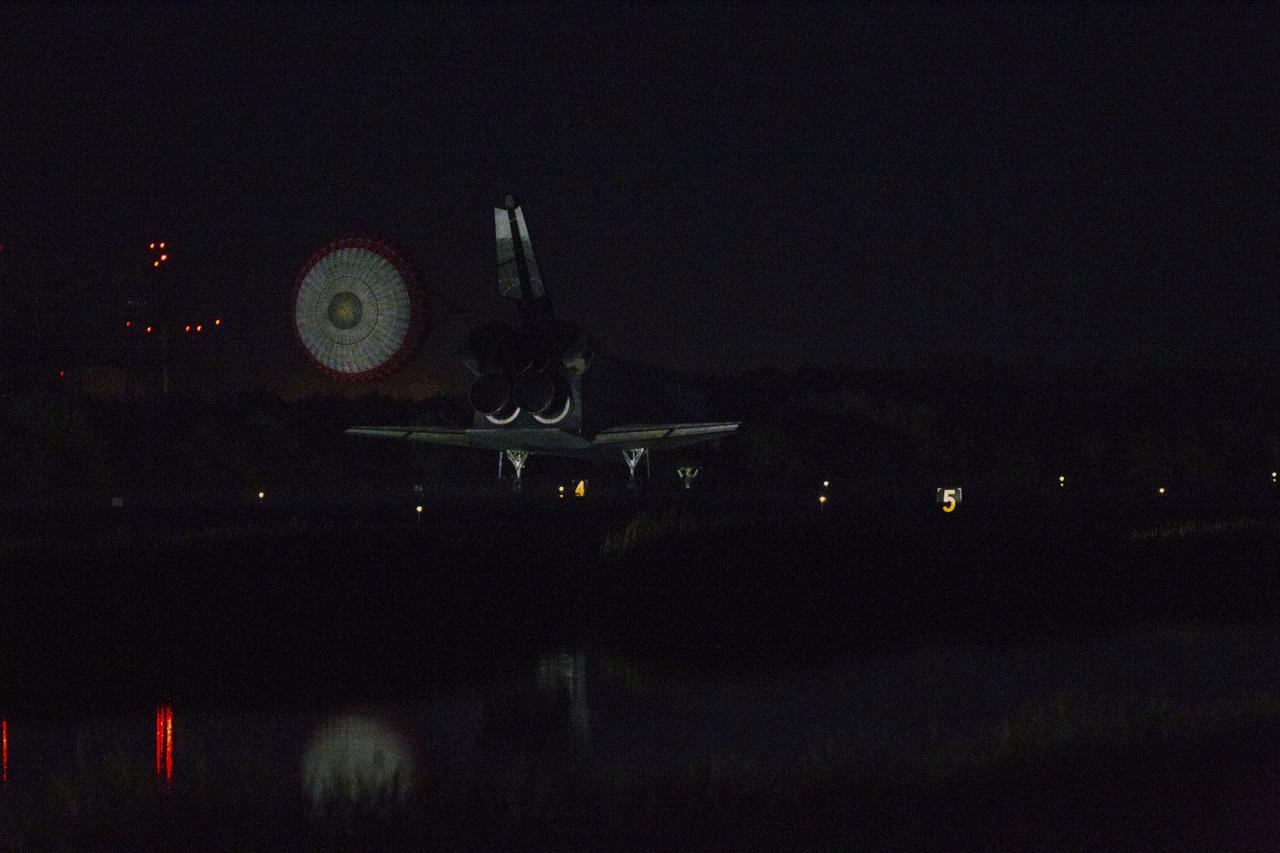 CAPE CANAVERAL, Fla. -- At the Shuttle Landing Facility at NASA's Kennedy Space Center in Florida, the drag chute trailing space shuttle Atlantis slows the almost indistinguishable shuttle as it lands on Runway 15 one final time.  Securing the space shuttle fleet's place in history, Atlantis marked the 26th nighttime landing of NASA's Space Shuttle Program and the 78th landing at Kennedy. Main gear touchdown was at 5:57:00 a.m. EDT, followed by nose gear touchdown at 5:57:20 a.m., and wheelstop at 5:57:54 a.m. On board are STS-135 Commander Chris Ferguson, Pilot Doug Hurley, and Mission Specialists Sandra Magnus and Rex Walheim.    On the 37th shuttle mission to the International Space Station, STS-135 delivered the Raffaello multi-purpose logistics module filled with more than 9,400 pounds of spare parts, equipment and supplies that will sustain station operations for the next year. STS-135 was the 33rd and final flight for Atlantis, which has spent 307 days in space, orbited Earth 4,848 times and traveled 125,935,769 miles. STS-135 also was the final mission of the Space Shuttle Program.  For more information, visit www.nasa.gov/mission_pages/shuttle/shuttlemissions/sts135/index.html. Photo credit: NASA/Kenny Allen