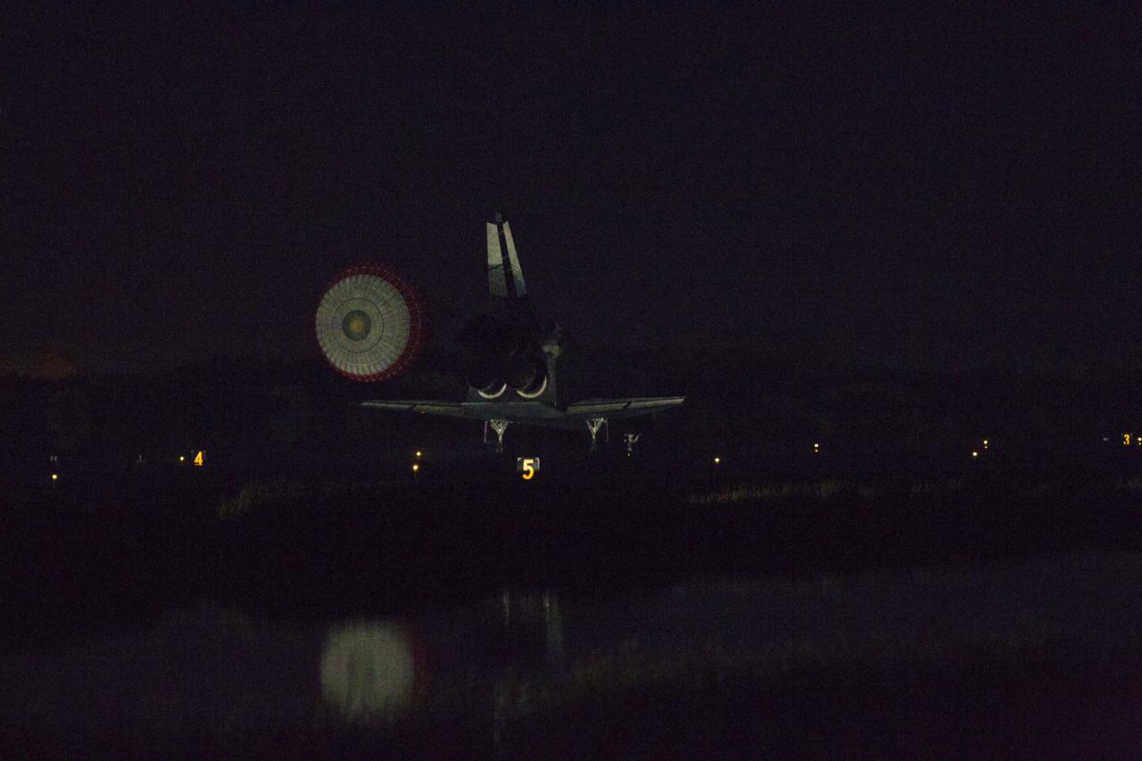 CAPE CANAVERAL, Fla. -- At the Shuttle Landing Facility at NASA's Kennedy Space Center in Florida, the drag chute trailing space shuttle Atlantis slows the almost indistinguishable shuttle as it lands on Runway 15 one final time.  Securing the space shuttle fleet's place in history, Atlantis marked the 26th nighttime landing of NASA's Space Shuttle Program and the 78th landing at Kennedy. Main gear touchdown was at 5:57:00 a.m. EDT, followed by nose gear touchdown at 5:57:20 a.m., and wheelstop at 5:57:54 a.m. On board are STS-135 Commander Chris Ferguson, Pilot Doug Hurley, and Mission Specialists Sandra Magnus and Rex Walheim.    On the 37th shuttle mission to the International Space Station, STS-135 delivered the Raffaello multi-purpose logistics module filled with more than 9,400 pounds of spare parts, equipment and supplies that will sustain station operations for the next year. STS-135 was the 33rd and final flight for Atlantis, which has spent 307 days in space, orbited Earth 4,848 times and traveled 125,935,769 miles. STS-135 also was the final mission of the Space Shuttle Program.  For more information, visit www.nasa.gov/mission_pages/shuttle/shuttlemissions/sts135/index.html. Photo credit: NASA/Kenny Allen