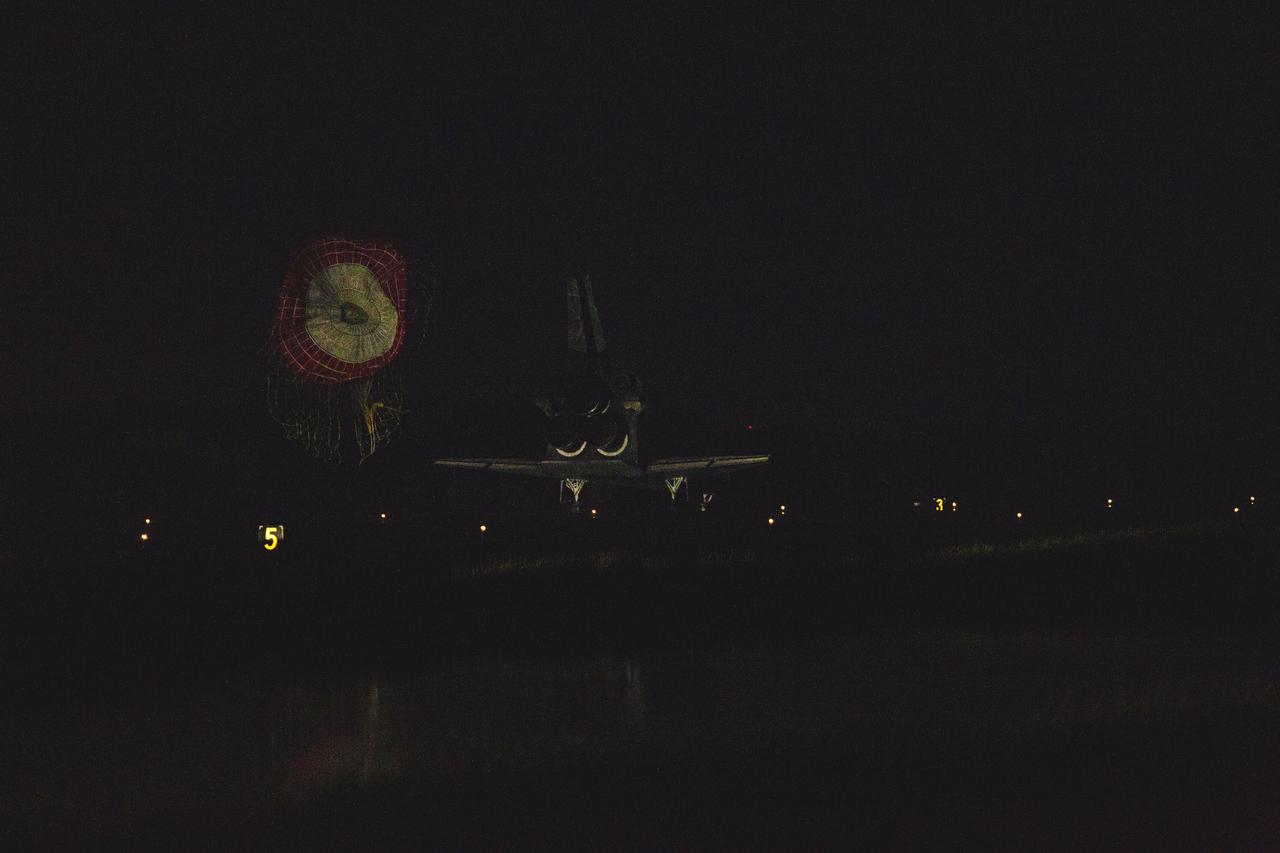 CAPE CANAVERAL, Fla. -- At the Shuttle Landing Facility at NASA's Kennedy Space Center in Florida, the drag chute trailing space shuttle Atlantis is ejected as the shuttle rolls to a stop on Runway 15 one final time.  Securing the space shuttle fleet's place in history, Atlantis marked the 26th nighttime landing of NASA's Space Shuttle Program and the 78th landing at Kennedy. Main gear touchdown was at 5:57:00 a.m. EDT, followed by nose gear touchdown at 5:57:20 a.m., and wheelstop at 5:57:54 a.m. On board are STS-135 Commander Chris Ferguson, Pilot Doug Hurley, and Mission Specialists Sandra Magnus and Rex Walheim.    On the 37th shuttle mission to the International Space Station, STS-135 delivered the Raffaello multi-purpose logistics module filled with more than 9,400 pounds of spare parts, equipment and supplies that will sustain station operations for the next year. STS-135 was the 33rd and final flight for Atlantis, which has spent 307 days in space, orbited Earth 4,848 times and traveled 125,935,769 miles. STS-135 also was the final mission of the Space Shuttle Program.  For more information, visit www.nasa.gov/mission_pages/shuttle/shuttlemissions/sts135/index.html. Photo credit: NASA/Kenny Allen