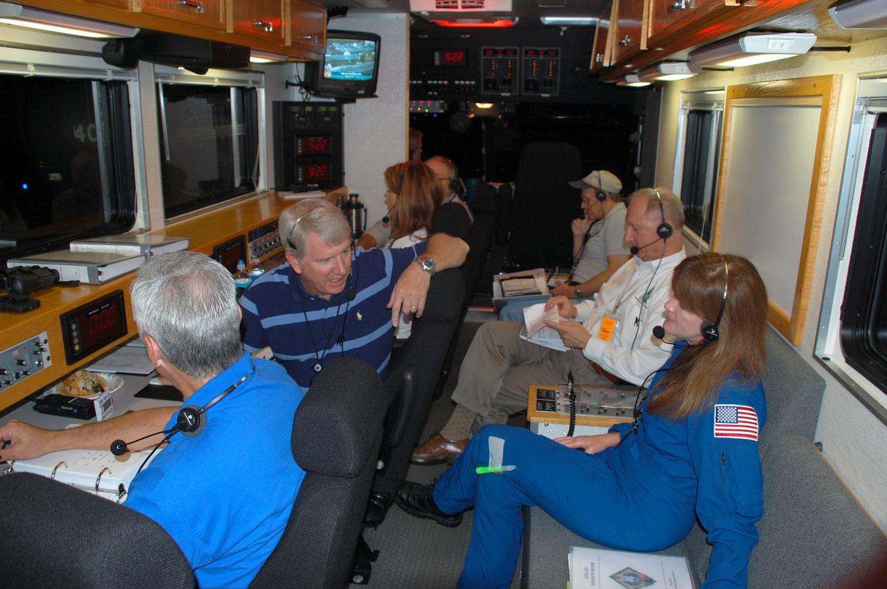 CAPE CANAVERAL, Fla. -- The Convoy Command Center vehicle is positioned on the Shuttle Landing Facility (SLF) at NASA's Kennedy Space Center in Florida awaiting the landing of space shuttle Atlantis. The command vehicle is equipped to control critical communications between the crew still aboard Atlantis and the Launch Control Center. The team will monitor the health of the orbiter systems and direct convoy operations made up of about 40 vehicles, including 25 specially designed vehicles to assist the crew in leaving the shuttle, and prepare the vehicle for towing from the SLF to its processing hangar. Accompanying the command convoy team are STS-135 Assistant Launch Director Pete Nickolenko (right), NASA astronaut Janet Kavandi and Chris Hasselbring, USA Operations Manager (left).      Securing the space shuttle fleet's place in history, Atlantis marks the 26th nighttime landing of NASA's Space Shuttle Program and the 78th landing at Kennedy. Atlantis and its crew delivered to the International Space Station the Raffaello multi-purpose logistics module packed with more than 9,400 pounds of spare parts, equipment and supplies that will sustain station operations for the next year. STS-135 is the 33rd and final flight for Atlantis and the final mission of the Space Shuttle Program. For more information, visit www.nasa.gov/mission_pages/shuttle/shuttlemissions/sts135/index.html. Photo credit: NASA/Ben Smegelsky