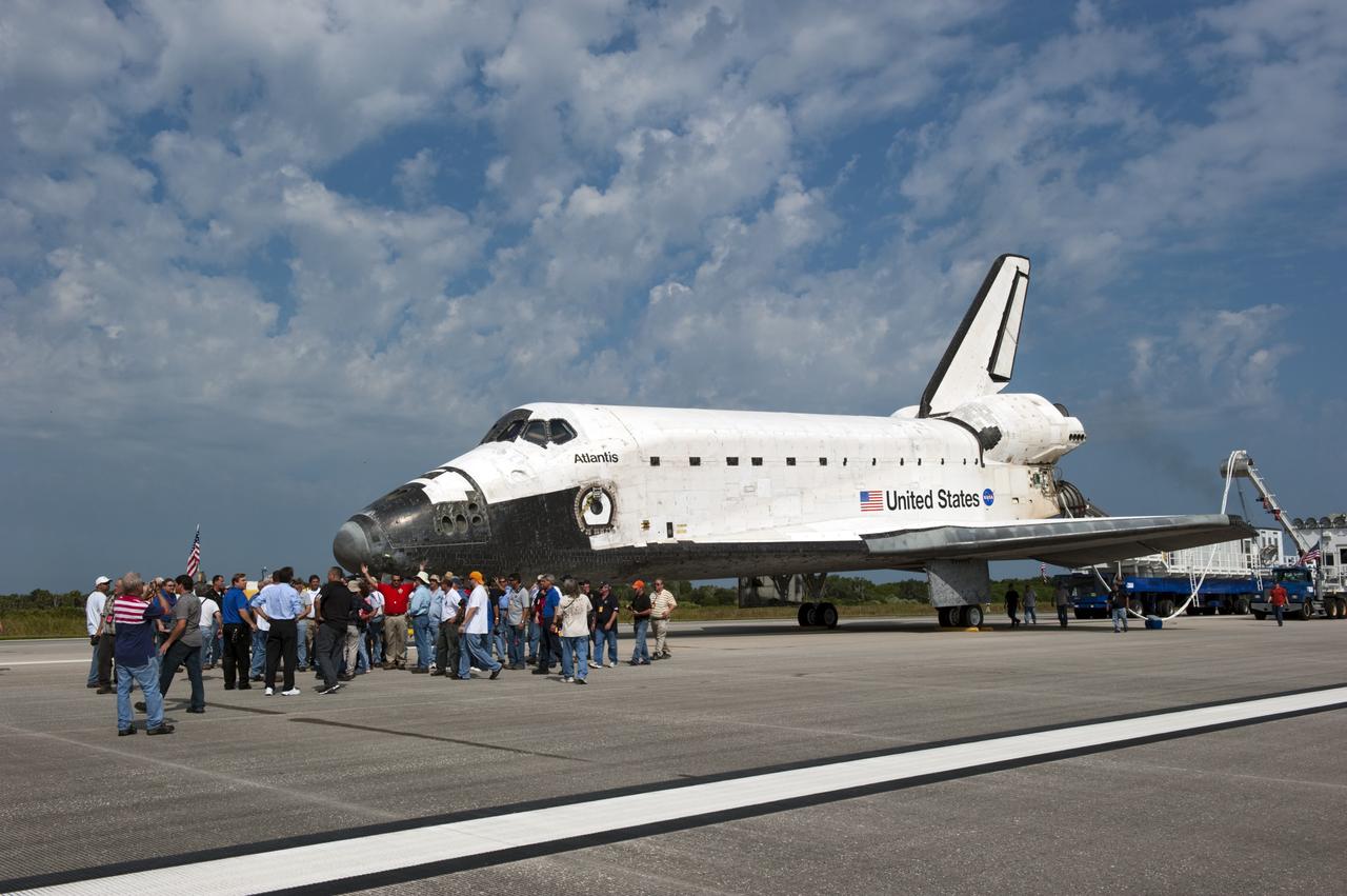 CAPE CANAVERAL, Fla. -- Employees admire space shuttle Atlantis as the landing convoy crew makes the vehicle safe for towing to Orbiter Processing Facility-2. Atlantis' final return to Earth on the Shuttle Landing Facility's Runway 15 at NASA's Kennedy Space Center in Florida occurred at 5:57 a.m. EDT July 21, 2011. Securing the space shuttle fleet's place in history, Atlantis marks the 26th nighttime landing of NASA's Space Shuttle Program and the 78th landing at Kennedy. Atlantis and its crew delivered to the International Space Station the Raffaello multi-purpose logistics module packed with more than 9,400 pounds of spare parts, equipment and supplies that will sustain station operations for the next year. STS-135 is the 33rd and final flight for Atlantis and the final mission of the Space Shuttle Program. For more information, visit www.nasa.gov/mission_pages/shuttle/shuttlemissions/sts135/index.html. Photo credit: NASA/Kim Shiflett