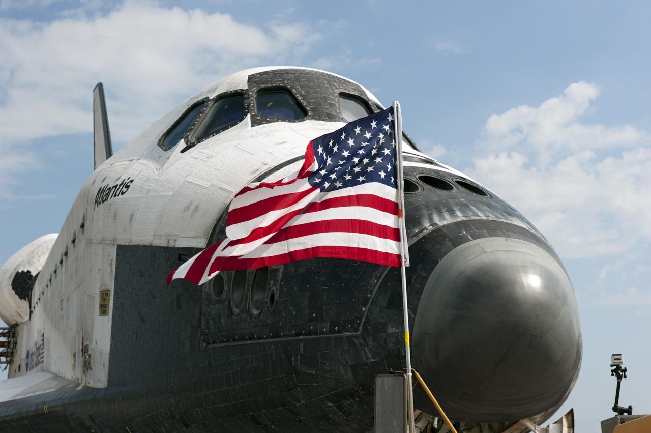 CAPE CANAVERAL, Fla. -- An American flag flaps proudly in the wind in front of space shuttle Atlantis on the Shuttle Landing Facility's Runway 15 at NASA's Kennedy Space Center in Florida. Atlantis' final return from space at 5:57 a.m. EDT completed the 13-day, 5.2-million-mile STS-135 mission. Securing the space shuttle fleet's place in history, Atlantis brought a close to the nation's Space Shuttle Program.              STS-135 delivered spare parts, equipment and supplies to the International Space Station. STS-135 was the 33rd and final flight for Atlantis, which has spent 307 days in space, orbited Earth 4,848 times and traveled 125,935,769 miles. For more information visit, www.nasa.gov/mission_pages/shuttle/shuttlemissions/sts135/index.html. Photo credit: NASA/Kim Shiflett