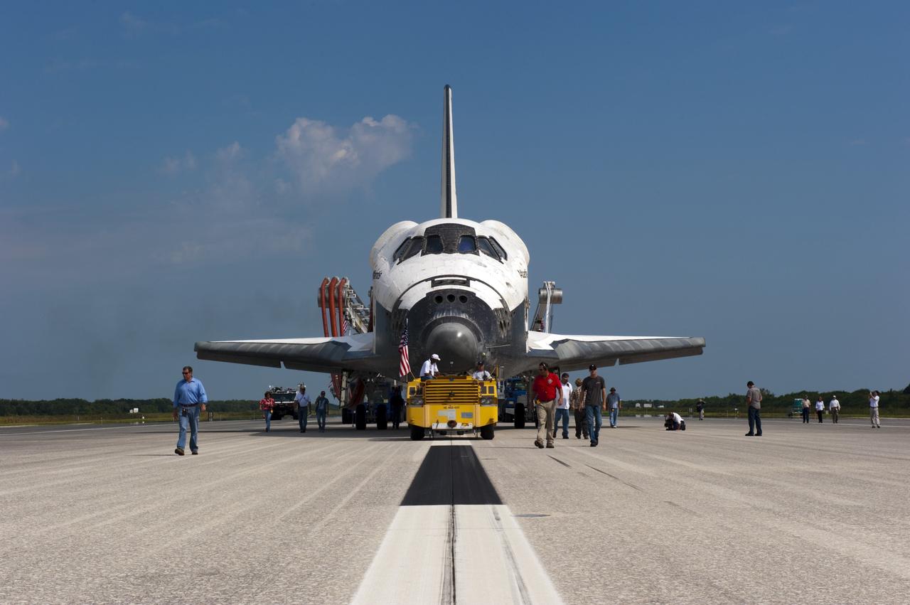 CAPE CANAVERAL, Fla. -- Workers accompany space shuttle Atlantis as it makes its slow trek from the Shuttle Landing Facility to Orbiter Processing Facility-2 for the last time. Atlantis' final return to Earth on Runway 15 at NASA's Kennedy Space Center in Florida occurred at 5:57 a.m. EDT July 21, 2011.                Securing the space shuttle fleet's place in history, Atlantis marks the 26th nighttime landing of NASA's Space Shuttle Program and the 78th landing at Kennedy. Atlantis and its crew delivered to the International Space Station the Raffaello multi-purpose logistics module packed with more than 9,400 pounds of spare parts, equipment and supplies that will sustain station operations for the next year. STS-135 is the 33rd and final flight for Atlantis and the final mission of the Space Shuttle Program. For more information, visit www.nasa.gov/mission_pages/shuttle/shuttlemissions/sts135/index.html. Photo credit: NASA/Kim Shiflett