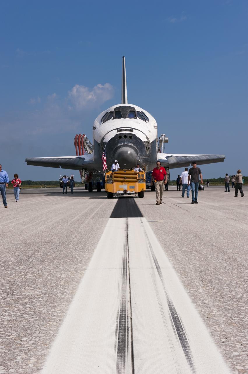 CAPE CANAVERAL, Fla. -- Workers accompany space shuttle Atlantis as it makes its slow trek from the Shuttle Landing Facility to Orbiter Processing Facility-2 for the last time. Atlantis' final return to Earth on Runway 15 at NASA's Kennedy Space Center in Florida occurred at 5:57 a.m. EDT July 21, 2011.                Securing the space shuttle fleet's place in history, Atlantis marks the 26th nighttime landing of NASA's Space Shuttle Program and the 78th landing at Kennedy. Atlantis and its crew delivered to the International Space Station the Raffaello multi-purpose logistics module packed with more than 9,400 pounds of spare parts, equipment and supplies that will sustain station operations for the next year. STS-135 is the 33rd and final flight for Atlantis and the final mission of the Space Shuttle Program. For more information, visit www.nasa.gov/mission_pages/shuttle/shuttlemissions/sts135/index.html. Photo credit: NASA/Kim Shiflett
