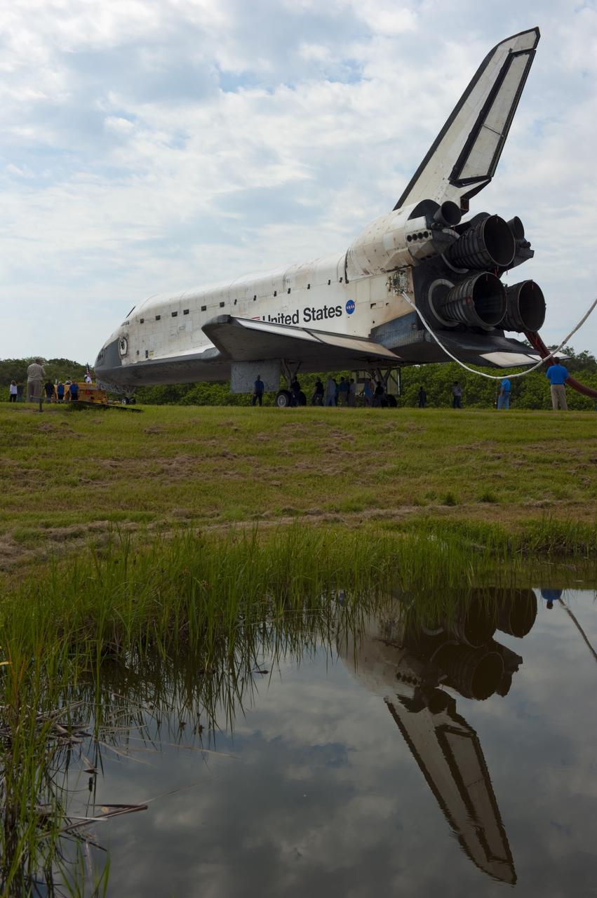 CAPE CANAVERAL, Fla. -- Workers accompany space shuttle Atlantis as it makes its slow trek from the Shuttle Landing Facility to Orbiter Processing Facility-2 for the last time. Atlantis' final return to Earth on Runway 15 at NASA's Kennedy Space Center in Florida occurred at 5:57 a.m. EDT July 21, 2011.                 Securing the space shuttle fleet's place in history, Atlantis marks the 26th nighttime landing of NASA's Space Shuttle Program and the 78th landing at Kennedy. Atlantis and its crew delivered to the International Space Station the Raffaello multi-purpose logistics module packed with more than 9,400 pounds of spare parts, equipment and supplies that will sustain station operations for the next year. STS-135 is the 33rd and final flight for Atlantis and the final mission of the Space Shuttle Program. For more information, visit www.nasa.gov/mission_pages/shuttle/shuttlemissions/sts135/index.html. Photo credit: NASA/Kim Shiflett