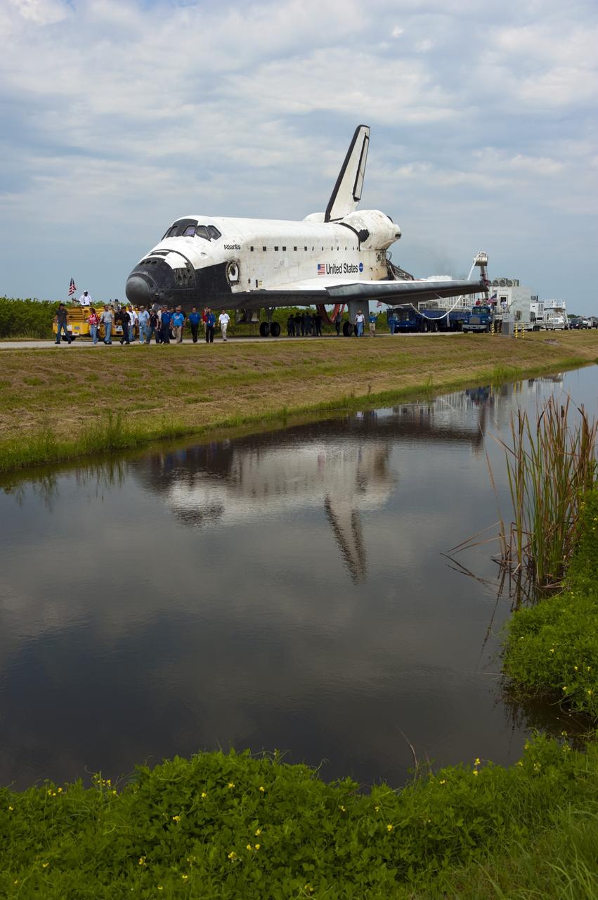 CAPE CANAVERAL, Fla. -- Media photograph space shuttle Atlantis as it is slowly towed from the Shuttle Landing Facility runway to Orbiter Processing Facility-2 for the last time. Atlantis' final return to Earth on Runway 15 at NASA's Kennedy Space Center in Florida occurred at 5:57 a.m. EDT July 21, 2011.                 Securing the space shuttle fleet's place in history, Atlantis marks the 26th nighttime landing of NASA's Space Shuttle Program and the 78th landing at Kennedy. Atlantis and its crew delivered to the International Space Station the Raffaello multi-purpose logistics module packed with more than 9,400 pounds of spare parts, equipment and supplies that will sustain station operations for the next year. STS-135 is the 33rd and final flight for Atlantis and the final mission of the Space Shuttle Program. For more information, visit www.nasa.gov/mission_pages/shuttle/shuttlemissions/sts135/index.html. Photo credit: NASA/Kim Shiflett