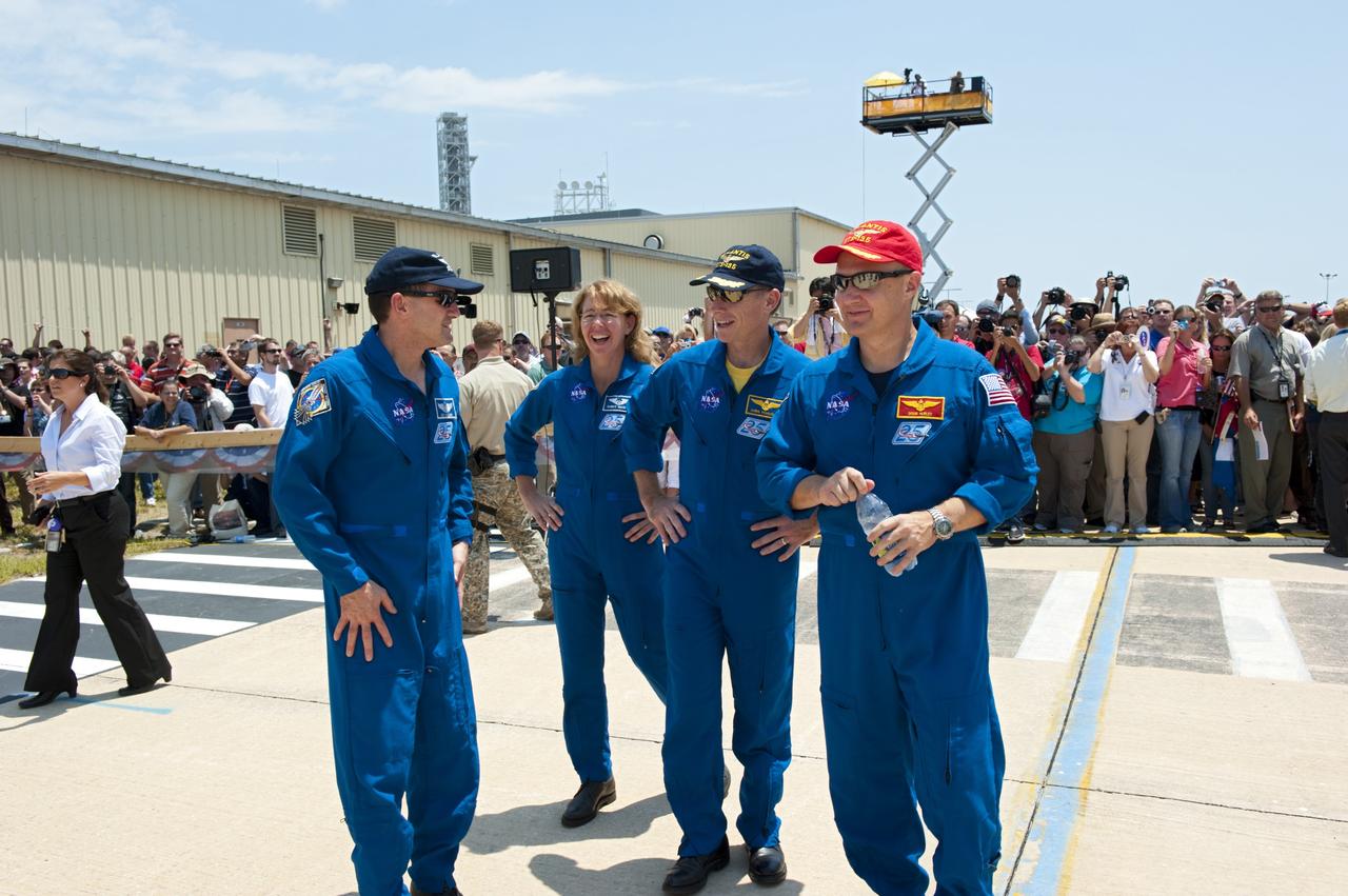 CAPE CANAVERAL, Fla. -- The STS-135 crew members stop for a photograph  after an employee appreciation event held in front of Orbiter Processing Facility-2 at NASA's Kennedy Space Center in Florida. Seen here are Mission Specialists Rex Walheim (left) and Sandy Magnus, Commander Chris Ferguson and Pilot Doug Hurley. Atlantis' final return to Earth occurred at 5:57 a.m. EDT July 21, 2011.                            Securing the space shuttle fleet's place in history, Atlantis marks the 26th nighttime landing of NASA's Space Shuttle Program and the 78th landing at Kennedy. Atlantis and its crew delivered to the International Space Station the Raffaello multi-purpose logistics module packed with more than 9,400 pounds of spare parts, equipment and supplies that will sustain station operations for the next year. STS-135 is the 33rd and final flight for Atlantis and the final mission of the Space Shuttle Program. For more information, visit www.nasa.gov/mission_pages/shuttle/shuttlemissions/sts135/index.html. Photo credit: NASA/Kim Shiflett