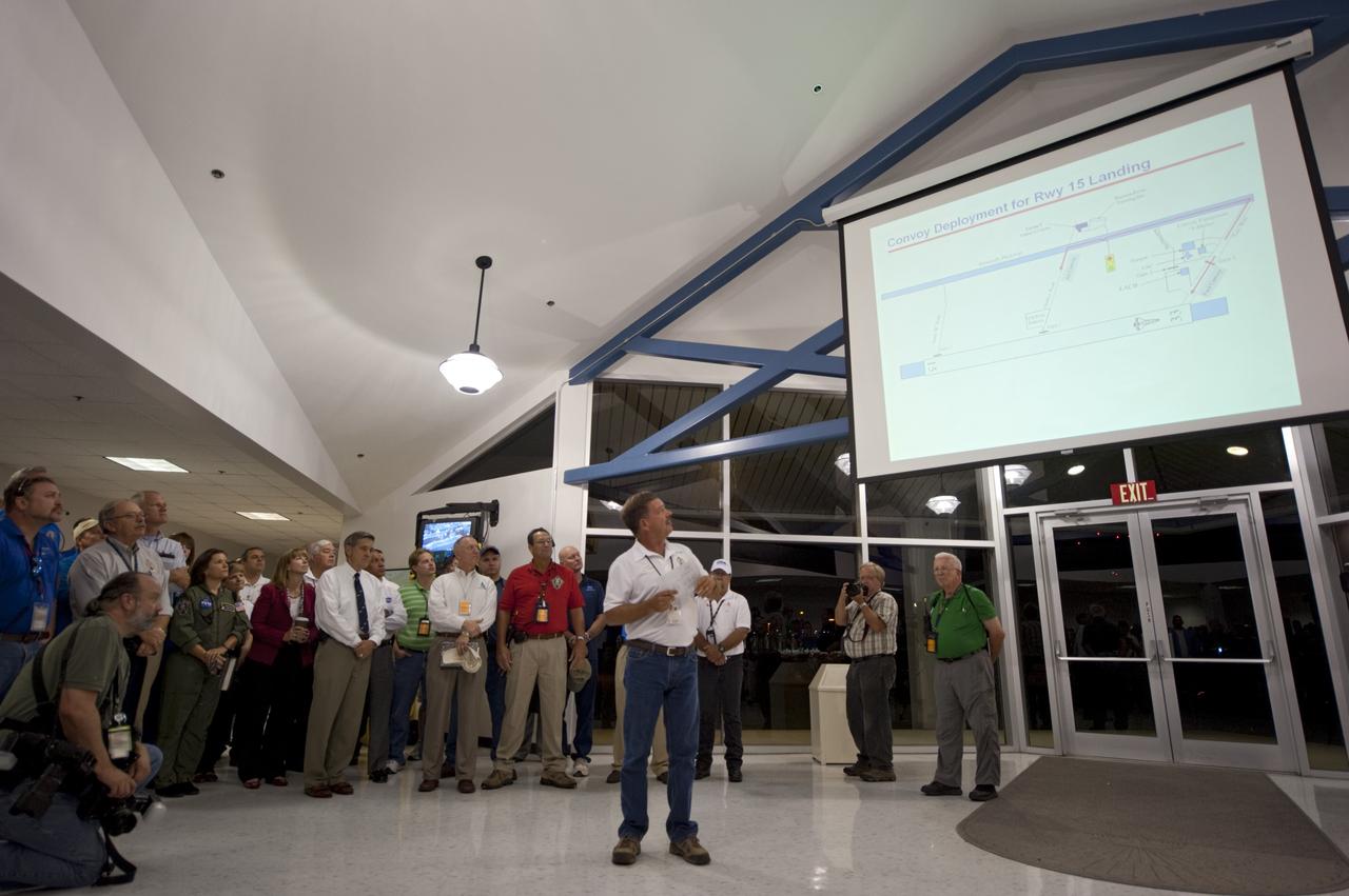 CAPE CANAVERAL, Fla. -- In the Flight Vehicle Support Building at NASA Kennedy Space Center's Shuttle Landing Facility (SLF), Mission Convoy Commander Tim Obrien strategies with NASA managers and convoy crew members during a prelanding meeting. A Convoy Command Center vehicle will be positioned near shuttle Atlantis on the SLF. The command vehicle is equipped to control critical communications between the crew still aboard Atlantis and the Launch Control Center. The team will monitor the health of the orbiter systems and direct convoy operations made up of about 40 vehicles, including 25 specially designed vehicles to assist the crew in leaving the shuttle, and prepare the vehicle for towing from the SLF to its processing hangar.  Securing the space shuttle fleet's place in history, Atlantis will mark the 26th nighttime landing of NASA's Space Shuttle Program and the 78th landing at Kennedy. Atlantis and its crew delivered to the International Space Station the Raffaello multi-purpose logistics module packed with more than 9,400 pounds of spare parts, equipment and supplies that will sustain station operations for the next year. STS-135 is the 33rd and final flight for Atlantis and final mission of the Space Shuttle Program. For more information, visit www.nasa.gov/mission_pages/shuttle/shuttlemissions/sts135/index.html. Photo credit: NASA/Kim Shiflett