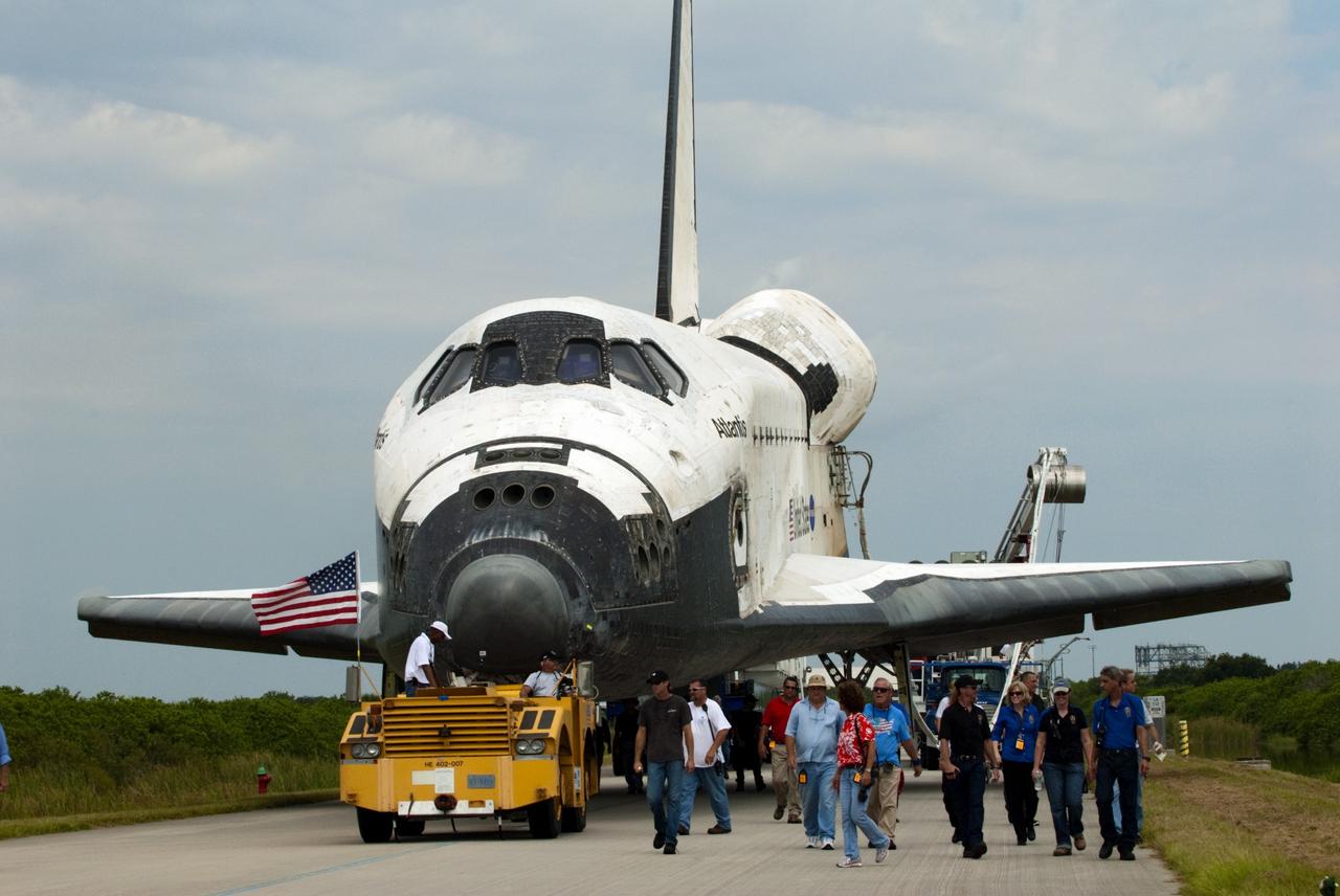 CAPE CANAVERAL, Fla. -- Space shuttle Atlantis and its employee entourage saunter along the towway from the Shuttle Landing Facility to the Orbiter Processing Facility at NASA's Kennedy Space Center in Florida.  Atlantis' final return from space at 5:57 a.m. EDT concluded the STS-135 mission, secured the space shuttle fleet's place in history and brought a close to America's Space Shuttle Program. Main gear touchdown was at 5:57:00 a.m. EDT, followed by nose gear touchdown at 5:57:20 a.m., and wheelstop at 5:57:54 a.m. On board were STS-135 Commander Chris Ferguson, Pilot Doug Hurley, and Mission Specialists Sandra Magnus and Rex Walheim.    On the 37th shuttle mission to the International Space Station, STS-135 delivered the Raffaello multi-purpose logistics module filled with more than 9,400 pounds of spare parts, equipment and supplies that will sustain station operations for the next year. STS-135 was the 33rd and final flight for Atlantis, which has spent 307 days in space, orbited Earth 4,848 times and traveled 125,935,769 miles, and also the final mission of the Space Shuttle Program.  For more information, visit www.nasa.gov/mission_pages/shuttle/shuttlemissions/sts135/index.html. Photo credit: NASA/Kim Shiflett