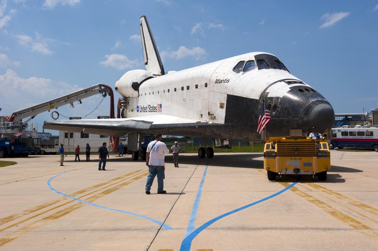 CAPE CANAVERAL, Fla. -- A "towback" vehicle slowly pulls space shuttle Atlantis toward Orbiter Processing Facility-2 at NASA's Kennedy Space Center in Florida. A purge unit that pumps conditioned air into a shuttle after landing is connected to Atlantis' aft end. Once inside the processing facility, Atlantis will be prepared for future public display at Kennedy's Visitor Complex.    Atlantis' final return from space at 5:57 a.m. EDT concluded the STS-135 mission, secured the space shuttle fleet's place in history and brought a close to America's Space Shuttle Program. Main gear touchdown was at 5:57:00 a.m. EDT, followed by nose gear touchdown at 5:57:20 a.m., and wheelstop at 5:57:54 a.m. On board were STS-135 Commander Chris Ferguson, Pilot Doug Hurley, and Mission Specialists Sandra Magnus and Rex Walheim.  On the 37th shuttle mission to the International Space Station, STS-135 delivered the Raffaello multi-purpose logistics module filled with more than 9,400 pounds of spare parts, equipment and supplies that will sustain station operations for the next year. STS-135 was the 33rd and final flight for Atlantis, which has spent 307 days in space, orbited Earth 4,848 times and traveled 125,935,769 miles, and also the final mission of the Space Shuttle Program.  For more information, visit www.nasa.gov/mission_pages/shuttle/shuttlemissions/sts135/index.html. Photo credit: NASA/Kim Shiflett