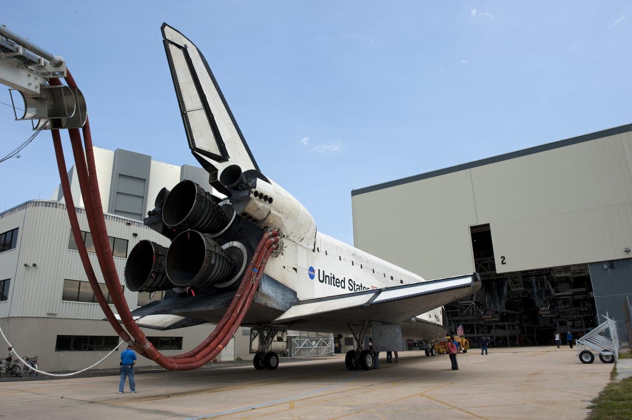 CAPE CANAVERAL, Fla. -- A "towback" vehicle slowly pulls space shuttle Atlantis toward the open door of Orbiter Processing Facility-2 at NASA's Kennedy Space Center in Florida. A purge unit that pumps conditioned air into a shuttle after landing is connected to Atlantis' aft end. Once inside the processing facility, Atlantis will be prepared for future public display at Kennedy's Visitor Complex.    Atlantis' final return from space at 5:57 a.m. EDT concluded the STS-135 mission, secured the space shuttle fleet's place in history and brought a close to America's Space Shuttle Program. Main gear touchdown was at 5:57:00 a.m. EDT, followed by nose gear touchdown at 5:57:20 a.m., and wheelstop at 5:57:54 a.m. On board were STS-135 Commander Chris Ferguson, Pilot Doug Hurley, and Mission Specialists Sandra Magnus and Rex Walheim.  On the 37th shuttle mission to the International Space Station, STS-135 delivered the Raffaello multi-purpose logistics module filled with more than 9,400 pounds of spare parts, equipment and supplies that will sustain station operations for the next year. STS-135 was the 33rd and final flight for Atlantis, which has spent 307 days in space, orbited Earth 4,848 times and traveled 125,935,769 miles, and also the final mission of the Space Shuttle Program.  For more information, visit www.nasa.gov/mission_pages/shuttle/shuttlemissions/sts135/index.html. Photo credit: NASA/Kim Shiflett