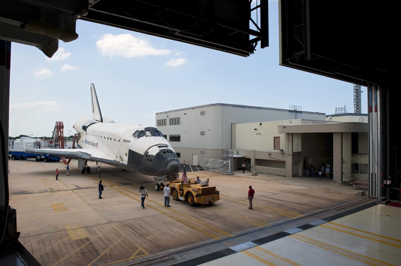 CAPE CANAVERAL, Fla. -- A "towback" vehicle slowly pulls space shuttle Atlantis toward the empty bay of Orbiter Processing Facility-2 at NASA's Kennedy Space Center in Florida. A purge unit that pumps conditioned air into a shuttle after landing is connected to Atlantis' aft end. Once inside the processing facility, Atlantis will be prepared for future public display at Kennedy's Visitor Complex.    Atlantis' final return from space at 5:57 a.m. EDT concluded the STS-135 mission, secured the space shuttle fleet's place in history and brought a close to America's Space Shuttle Program. Main gear touchdown was at 5:57:00 a.m. EDT, followed by nose gear touchdown at 5:57:20 a.m., and wheelstop at 5:57:54 a.m. On board were STS-135 Commander Chris Ferguson, Pilot Doug Hurley, and Mission Specialists Sandra Magnus and Rex Walheim.  On the 37th shuttle mission to the International Space Station, STS-135 delivered the Raffaello multi-purpose logistics module filled with more than 9,400 pounds of spare parts, equipment and supplies that will sustain station operations for the next year. STS-135 was the 33rd and final flight for Atlantis, which has spent 307 days in space, orbited Earth 4,848 times and traveled 125,935,769 miles, and also the final mission of the Space Shuttle Program.  For more information, visit www.nasa.gov/mission_pages/shuttle/shuttlemissions/sts135/index.html. Photo credit: NASA/Kim Shiflett