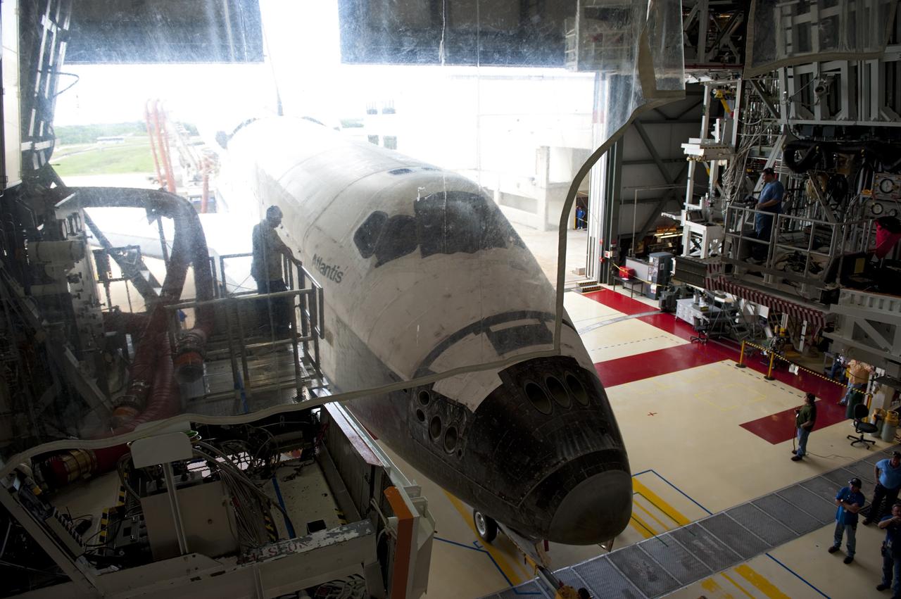CAPE CANAVERAL, Fla. -- At NASA's Kennedy Space Center in Florida, employees in Orbiter Processing Facility-2 monitor the alignment of space shuttle Atlantis as it is towed into the empty bay. Once inside the processing facility, Atlantis will be prepared for future public display at Kennedy's Visitor Complex.    Atlantis' final return from space at 5:57 a.m. EDT concluded the STS-135 mission, secured the space shuttle fleet's place in history and brought a close to America's Space Shuttle Program. Main gear touchdown was at 5:57:00 a.m. EDT, followed by nose gear touchdown at 5:57:20 a.m., and wheelstop at 5:57:54 a.m. On board were STS-135 Commander Chris Ferguson, Pilot Doug Hurley, and Mission Specialists Sandra Magnus and Rex Walheim.  On the 37th shuttle mission to the International Space Station, STS-135 delivered the Raffaello multi-purpose logistics module filled with more than 9,400 pounds of spare parts, equipment and supplies that will sustain station operations for the next year. STS-135 was the 33rd and final flight for Atlantis, which has spent 307 days in space, orbited Earth 4,848 times and traveled 125,935,769 miles, and also the final mission of the Space Shuttle Program.  For more information, visit www.nasa.gov/mission_pages/shuttle/shuttlemissions/sts135/index.html. Photo credit: NASA/Kim Shiflett