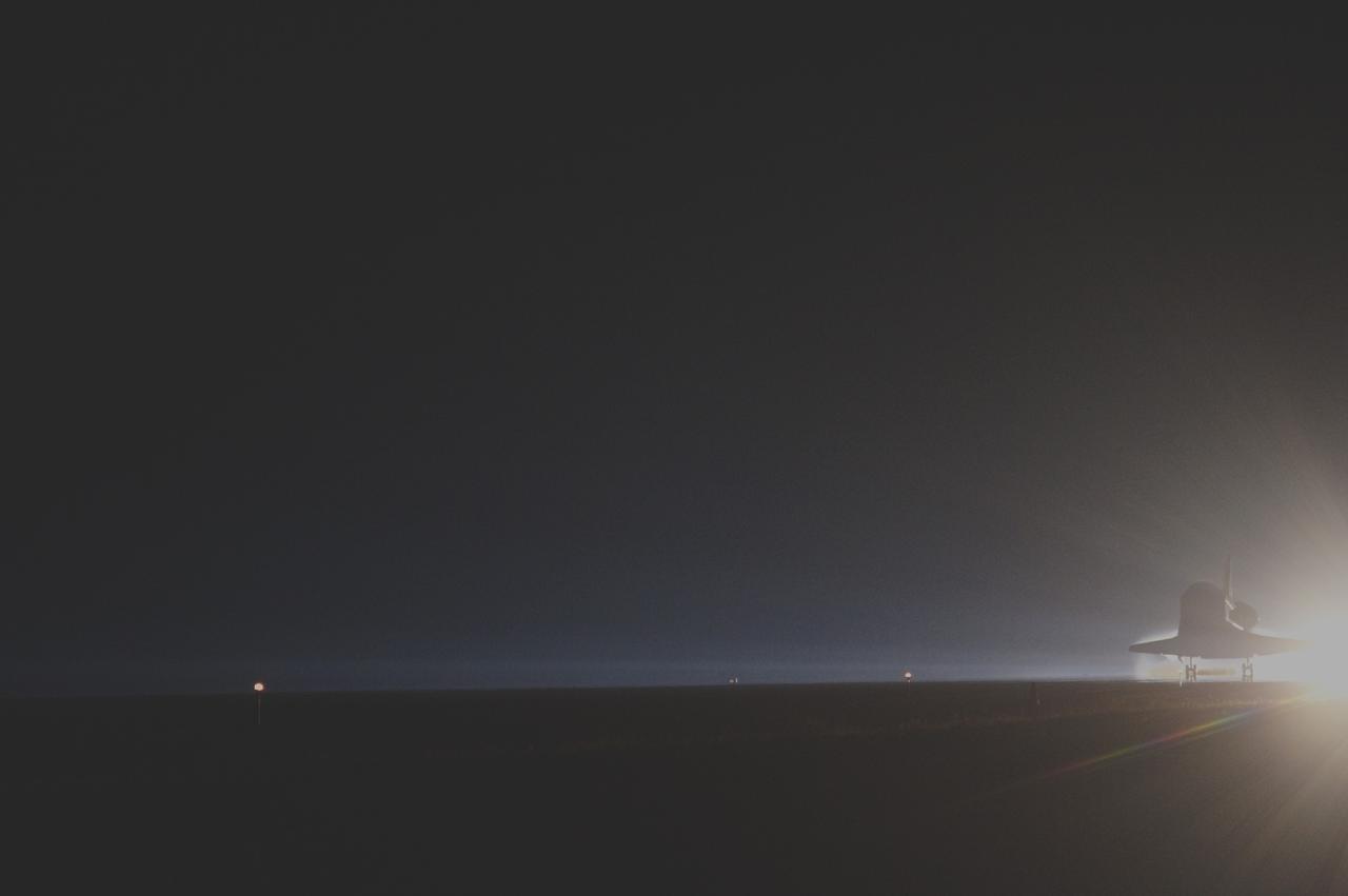 CAPE CANAVERAL, Fla. -- Space shuttle Atlantis glides out of the darkness onto the Shuttle Landing Facility's  Runway 15 at NASA's Kennedy Space Center in Florida. Atlantis marked the 26th nighttime landing of NASA's Space Shuttle Program and the 78th landing at Kennedy. Main gear touchdown was at 5:57:00 a.m. EDT, followed by nose gear touchdown at 5:57:20 a.m., and wheelstop at 5:57:54 a.m. On board are STS-135 Commander Chris Ferguson, Pilot Doug Hurley, and Mission Specialists Sandra Magnus and Rex Walheim.    On the 37th shuttle mission to the International Space Station, STS-135 delivered the Raffaello multi-purpose logistics module filled with more than 9,400 pounds of spare parts, equipment and supplies that will sustain station operations for the next year. STS-135 was the 33rd and final flight for Atlantis, which has spent 307 days in space, orbited Earth 4,848 times and traveled 125,935,769 miles. It was the final mission of the Space Shuttle Program.  For more information, visit www.nasa.gov/mission_pages/shuttle/shuttlemissions/sts135/index.html. Photo credit: NASA/Sandra Joseph and Kevin O'Connell