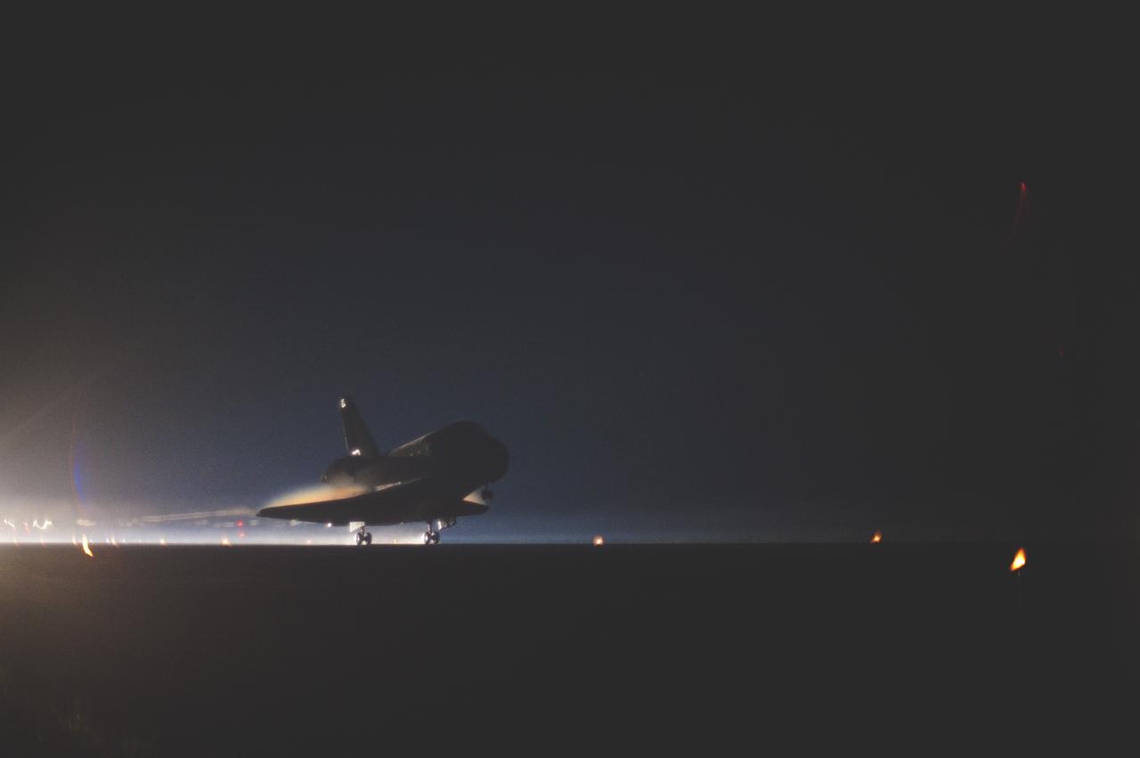 CAPE CANAVERAL, Fla. -- Space shuttle Atlantis glides out of the darkness onto the Shuttle Landing Facility's  Runway 15 at NASA's Kennedy Space Center in Florida. Atlantis marked the 26th nighttime landing of NASA's Space Shuttle Program and the 78th landing at Kennedy. Main gear touchdown was at 5:57:00 a.m. EDT, followed by nose gear touchdown at 5:57:20 a.m., and wheelstop at 5:57:54 a.m. On board are STS-135 Commander Chris Ferguson, Pilot Doug Hurley, and Mission Specialists Sandra Magnus and Rex Walheim.    On the 37th shuttle mission to the International Space Station, STS-135 delivered the Raffaello multi-purpose logistics module filled with more than 9,400 pounds of spare parts, equipment and supplies that will sustain station operations for the next year. STS-135 was the 33rd and final flight for Atlantis, which has spent 307 days in space, orbited Earth 4,848 times and traveled 125,935,769 miles.  It was the final mission of the Space Shuttle Program.  For more information, visit www.nasa.gov/mission_pages/shuttle/shuttlemissions/sts135/index.html. Photo credit: NASA/Sandra Joseph and Kevin O'Connell