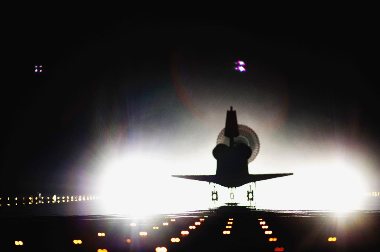 CAPE CANAVERAL, Fla. -- Space shuttle Atlantis moves out of its xenon spotlights and into the history books as it lands on Runway 15 at the Shuttle Landing Facility at NASA's Kennedy Space Center in Florida. Atlantis marked the 26th nighttime landing of NASA's Space Shuttle Program and the 78th landing at Kennedy. Main gear touchdown was at 5:57:00 a.m. EDT, followed by nose gear touchdown at 5:57:20 a.m., and wheelstop at 5:57:54 a.m. On board are STS-135 Commander Chris Ferguson, Pilot Doug Hurley, and Mission Specialists Sandy Magnus and Rex Walheim.    On the 37th shuttle mission to the International Space Station, STS-135 delivered the Raffaello multi-purpose logistics module filled with more than 9,400 pounds of spare parts, equipment and supplies that will sustain station operations for the next year. STS-135 was the 33rd and final flight for Atlantis, which has spent 307 days in space, orbited Earth 4,848 times and traveled 125,935,769 miles. STS-135 also was the final mission of the Space Shuttle Program.  For more information, visit www.nasa.gov/mission_pages/shuttle/shuttlemissions/sts135/index.html. Photo credit: NASA/Tom Farrar and Tony Gray