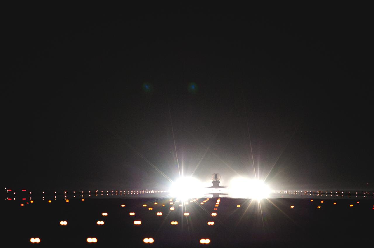CAPE CANAVERAL, Fla. -- Xenon lights positioned at the end of Runway 15 reveal that the drag chute has deployed behind space shuttle Atlantis to slow the shuttle as it lands for the last time at the Shuttle Landing Facility at NASA's Kennedy Space Center in Florida. Securing the space shuttle fleet's place in history, Atlantis marked the 26th nighttime landing of NASA's Space Shuttle Program and the 78th landing at Kennedy. Main gear touchdown was at 5:57:00 a.m. EDT, followed by nose gear touchdown at 5:57:20 a.m., and wheelstop at 5:57:54 a.m. On board are STS-135 Commander Chris Ferguson, Pilot Doug Hurley, and Mission Specialists Sandy Magnus and Rex Walheim.    On the 37th shuttle mission to the International Space Station, STS-135 delivered the Raffaello multi-purpose logistics module filled with more than 9,400 pounds of spare parts, equipment and supplies that will sustain station operations for the next year. STS-135 was the 33rd and final flight for Atlantis, which has spent 307 days in space, orbited Earth 4,848 times and traveled 125,935,769 miles. STS-135 also was the final mission of the Space Shuttle Program.  For more information, visit www.nasa.gov/mission_pages/shuttle/shuttlemissions/sts135/index.html. Photo credit: NASA/Tom Farrar and Tony Gray