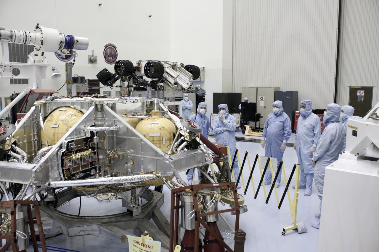 Cape Canaveral, Fla. -- Dr. Charles Elachi, Director of Advanced Planning at NASA's Jet Propulsion Laboratory, third from left, looks over the rocket-powered descent stage for NASA's Mars Science Laboratory (MSL) rover, known as Curiosity, as it sits in a work stand at the Payload Hazardous Servicing Facility at NASA's Kennedy Space Center in Florida. A United Launch Alliance Atlas V-541 configuration will be used to loft MSL into space. Curiosity’s 10 science instruments are designed to search for evidence on whether Mars has had environments favorable to microbial life, including chemical ingredients for life. The unique rover will use a laser to look inside rocks and release its gasses so that the rover’s spectrometer can analyze and send the data back to Earth. MSL is scheduled to launch from Cape Canaveral Air Force Station in Florida Nov. 25 with a window extending to Dec. 18 and arrival at Mars Aug. 2012. For more information, visit http://www.nasa.gov/msl. Photo credit: NASA/Jim Grossmann